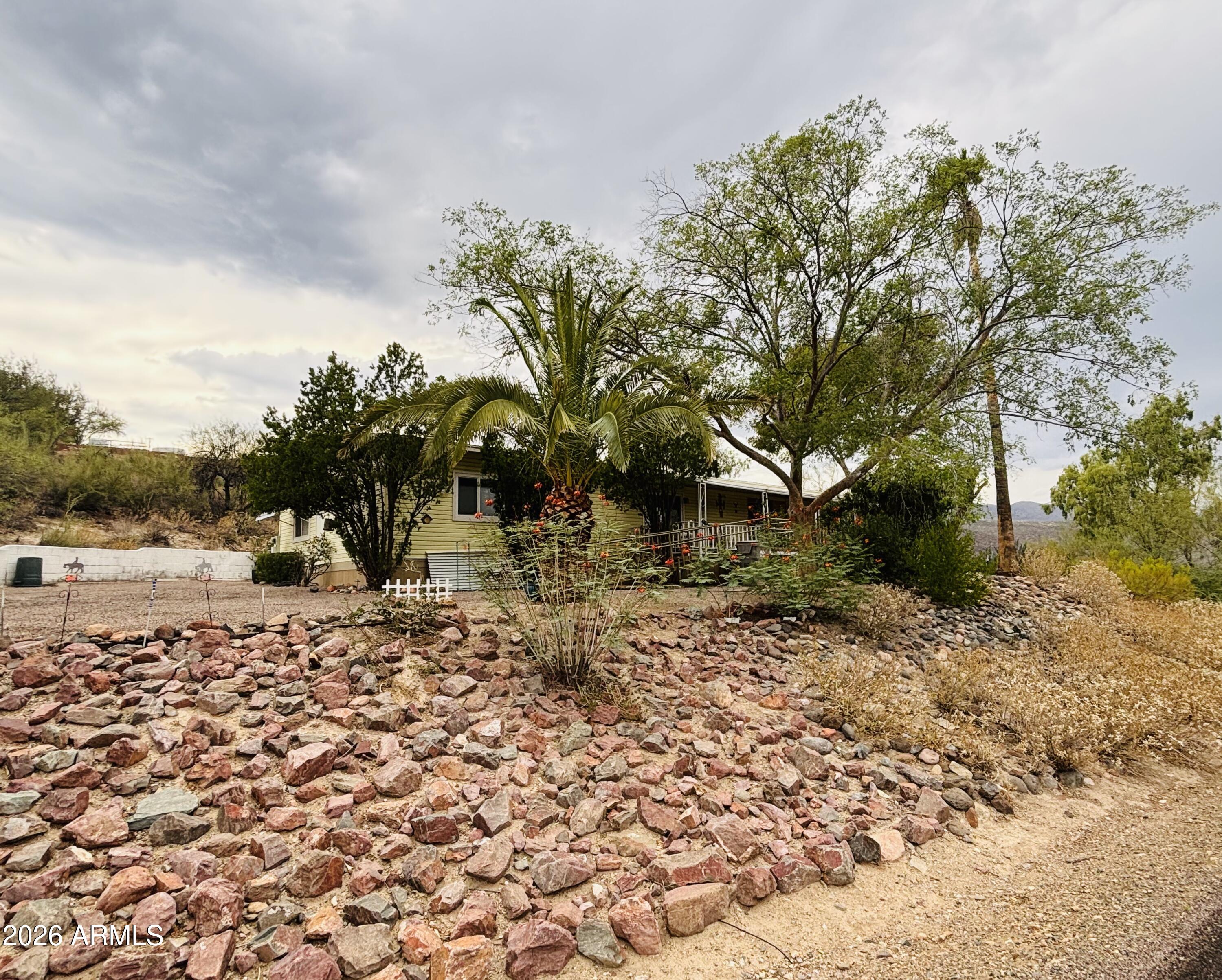 Perched above Black Canyon City, this hillside home sits on a half acre and packs a mighty punch!  With breathtaking mountain views, mature trees and landscaping this immaculately maintained and loved home offers easy living with easy maintenance. Two primary bedrooms, covered deck, covered patio, new windows, new flooring, updated bathrooms, interior paint and special touches throughout this charming home. Welcome Home!
