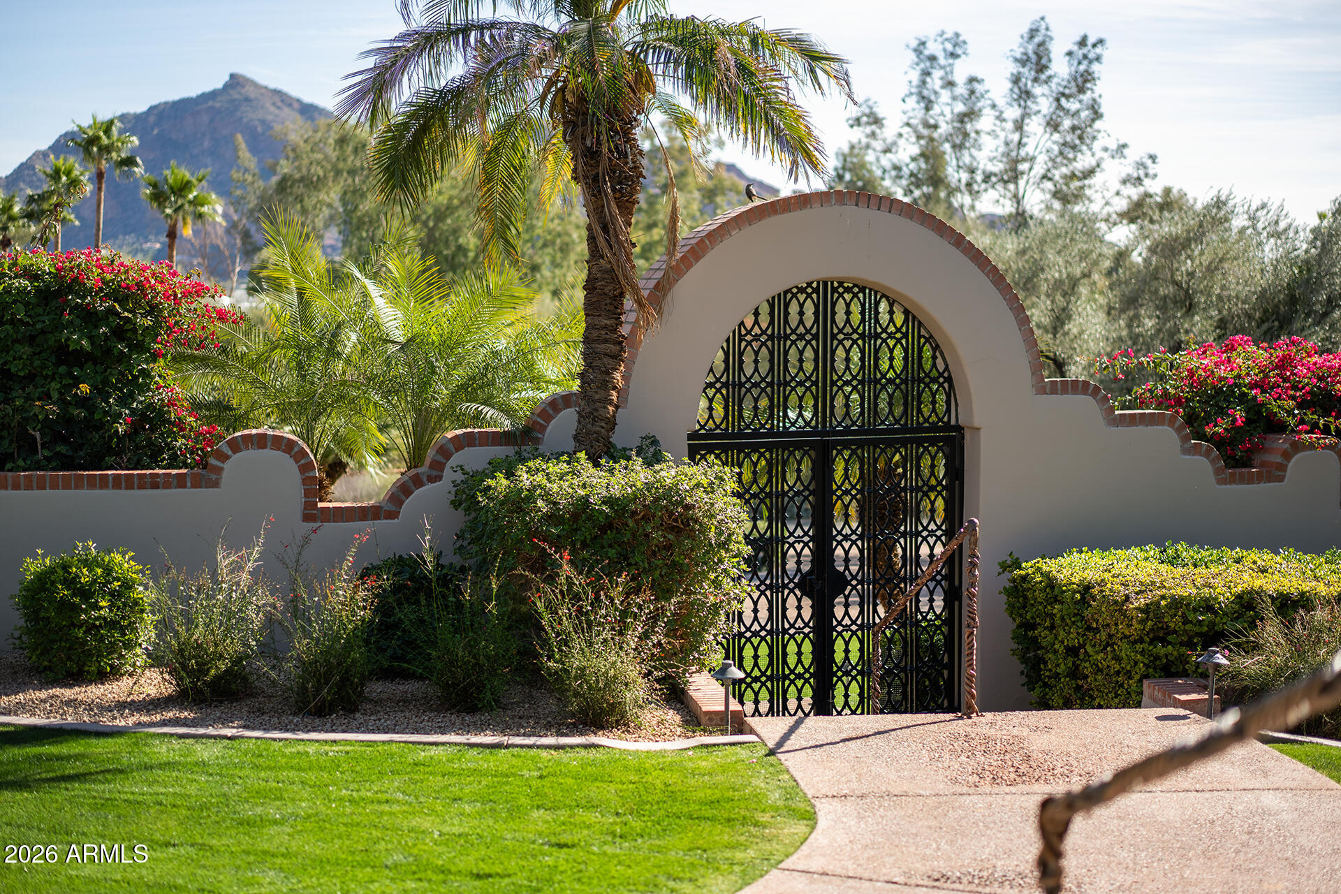 Located in the sought-after gated community of Clearwater Hills, this one-acre privately gated estate offers stunning views of Camelback Mountain and the Phoenix Mountain Preserve through picture windows throughout the home. The interior spaces are bathed in natural light, accentuating warm wood floors and natural stone accents. The floor plan offers a mid-century vibe, featuring a circular entry that leads to a sophisticated bar and club room. A cozy den with a stone fireplace overlooks the private front courtyard, while the large formal dining room is ideal for entertaining. The newly renovated kitchen is equipped with custom cabinetry, quartz countertops, top-of-the-line appliances, and a breakfast room with floor-to-ceiling windows. The split floor plan provides two large en-suite bedrooms separate from the primary suite. The primary suite serves as a private retreat, complete with a sitting area, fireplace, and a newly remodeled spa bathroom. Additionally, there is a fourth bedroom currently utilized as a home office.

The outdoor spaces are designed for entertaining and taking in the desert views, featuring a heated lap pool and beautifully manicured lawns that contrast with the curated desert landscaping. This home perfectly captures the essence of upscale living in Paradise Valley.