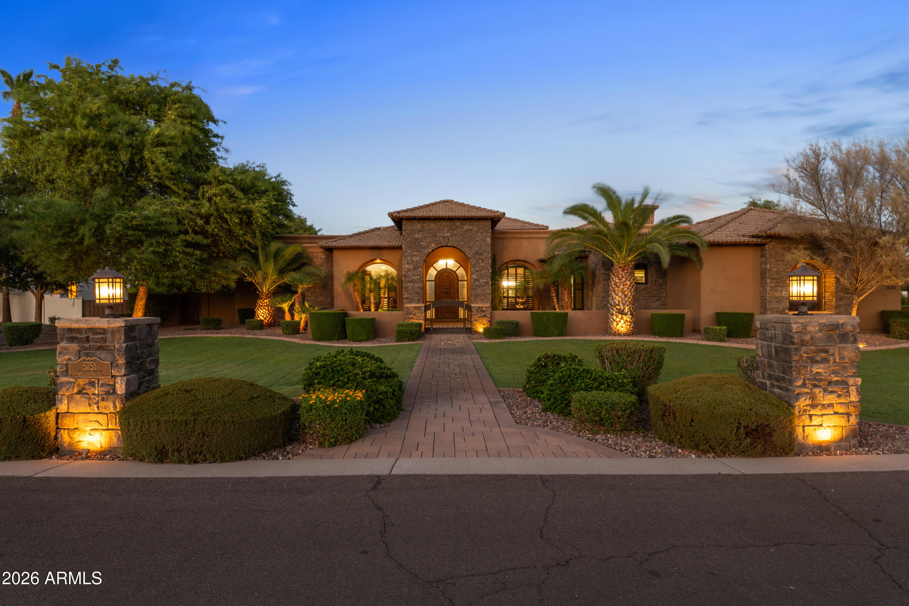 Designed for both entertaining and everyday living, Wilson Drive seamlessly blends luxury, comfort, and functionality. Situated on nearly an acre and framed by mountain views, the resort-style backyard is a private oasis featuring a built-in barbecue, sparkling pool with waterfall grotto, slide and spa, and a versatile sport court ideal for basketball, volleyball, or pickleball. Additional outdoor amenities include an expansive covered patio, elegant travertine stone hardscaping, a misting system, and low-maintenance turf grass.

At the heart of the home, the chef's kitchen is thoughtfully appointed with premium appliances, a wine refrigerator, ice maker, and convenient refrigerator drawers. A large center island and breakfast bar create the perfect gathering space. Four of the five spacious bedrooms, along with the versatile flex room, offer the privacy and convenience of its own en-suite bathroom. Completing the home is an oversized four-car garage with air conditioning, providing a comfortable, temperature-controlled environment for vehicles, storage, hobbies, or a home gym.

Wilson Drive offers a combination of resort-style living, thoughtful design and a premier location. Welcome home to luxury living.