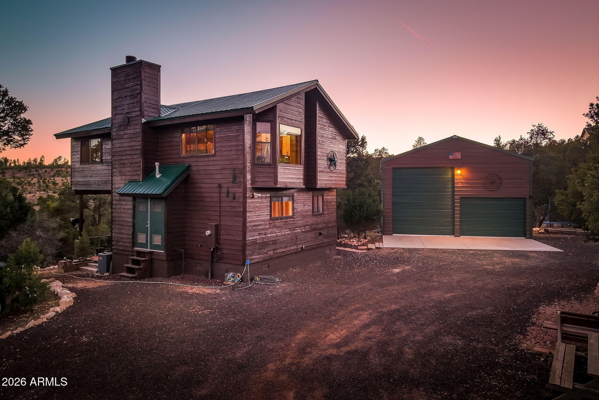 Impeccably maintained pine-sided home situated on 2 acres backing the Apache-Sitgreaves National Forests, offering privacy, space, and exceptional views.

This 3-bedroom, 1.5-bath home features a beautifully finished upper level with knotty pine interior, exposed beams, and abundant natural light from numerous windows, including a bay window in the dining area. The living room showcases a wood-burning fireplace with floor-to-ceiling rock surround, creating a warm and inviting atmosphere.

The updated kitchen includes knotty alder cabinetry, pantry, composite countertops, and stainless steel appliances, including a double oven. Additional features include propane furnace and central air conditioning.

Outdoor amenities are extensive:

Covered and uncovered decks ideal for enjoying l views and stargazing

30x40 metal garage with 25' RV door, 30-amp plug-in, and wood stove

Additional parking pad

10x17 bonus "man cave" structure

8x12 storage shed

Treehouse and fire pit area

Property is served by a shared well with low annual fee ($300/year). A rare opportunity to own a well-equipped property with direct access to national forest and wide-open space.