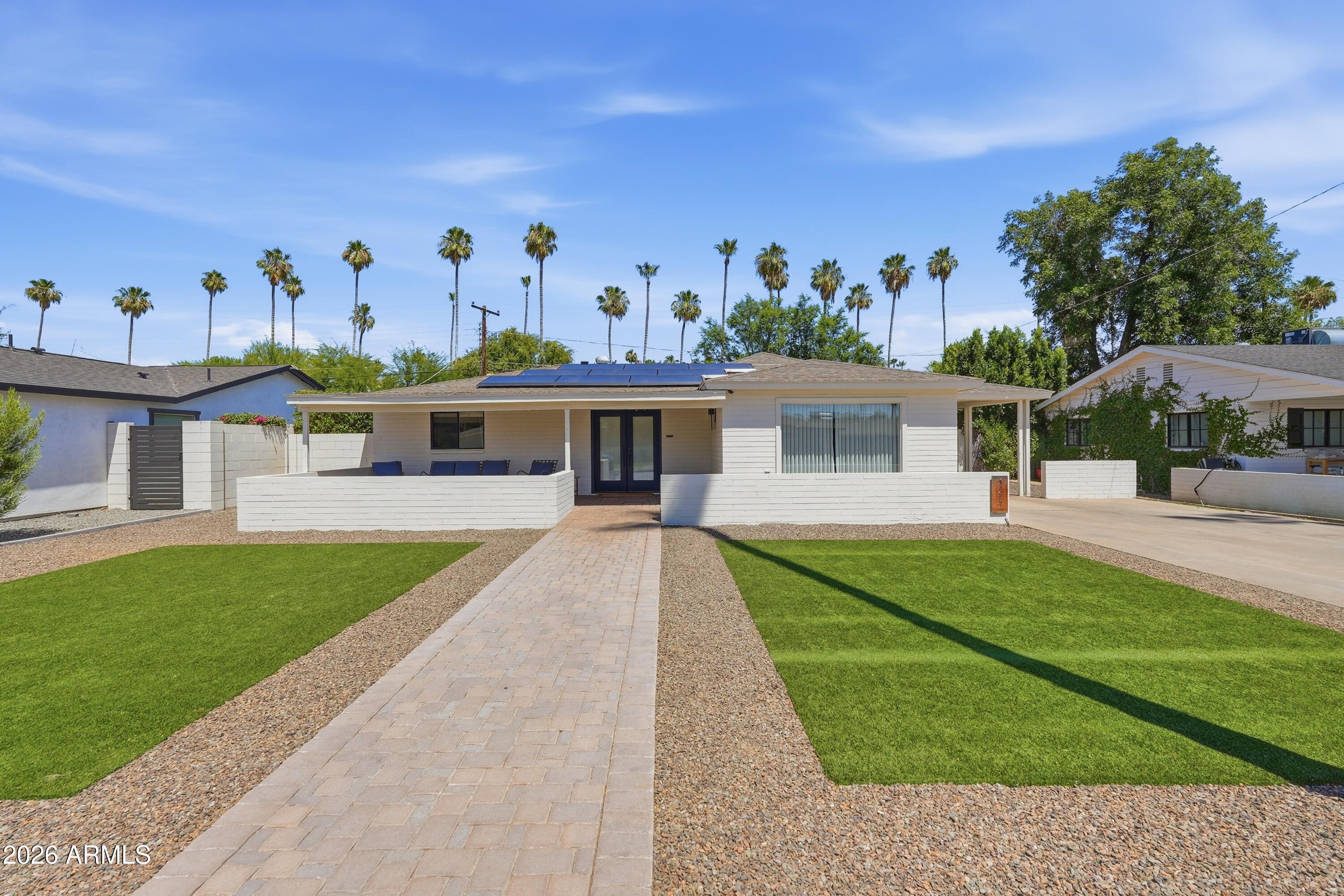 Amazing Arcadia Lite location on a palm lined family-friendly street. Inside you will find gorgeous real hardwood floors flowing through a bright, open layout perfect for entertaining. The primary suite is a true retreat, featuring beautifully designed custom closets and a double-sided gas fireplace between the bedroom and the spa-like bathroom. Outside, enjoy a private backyard oasis featuring premium artificial turf and an inline gas firepit, offering year-round lushness with low maintenance and minimal water usage. This turn-key home features fully owned Tesla solar panels and a dedicated EV charger. This beautiful home has everything.