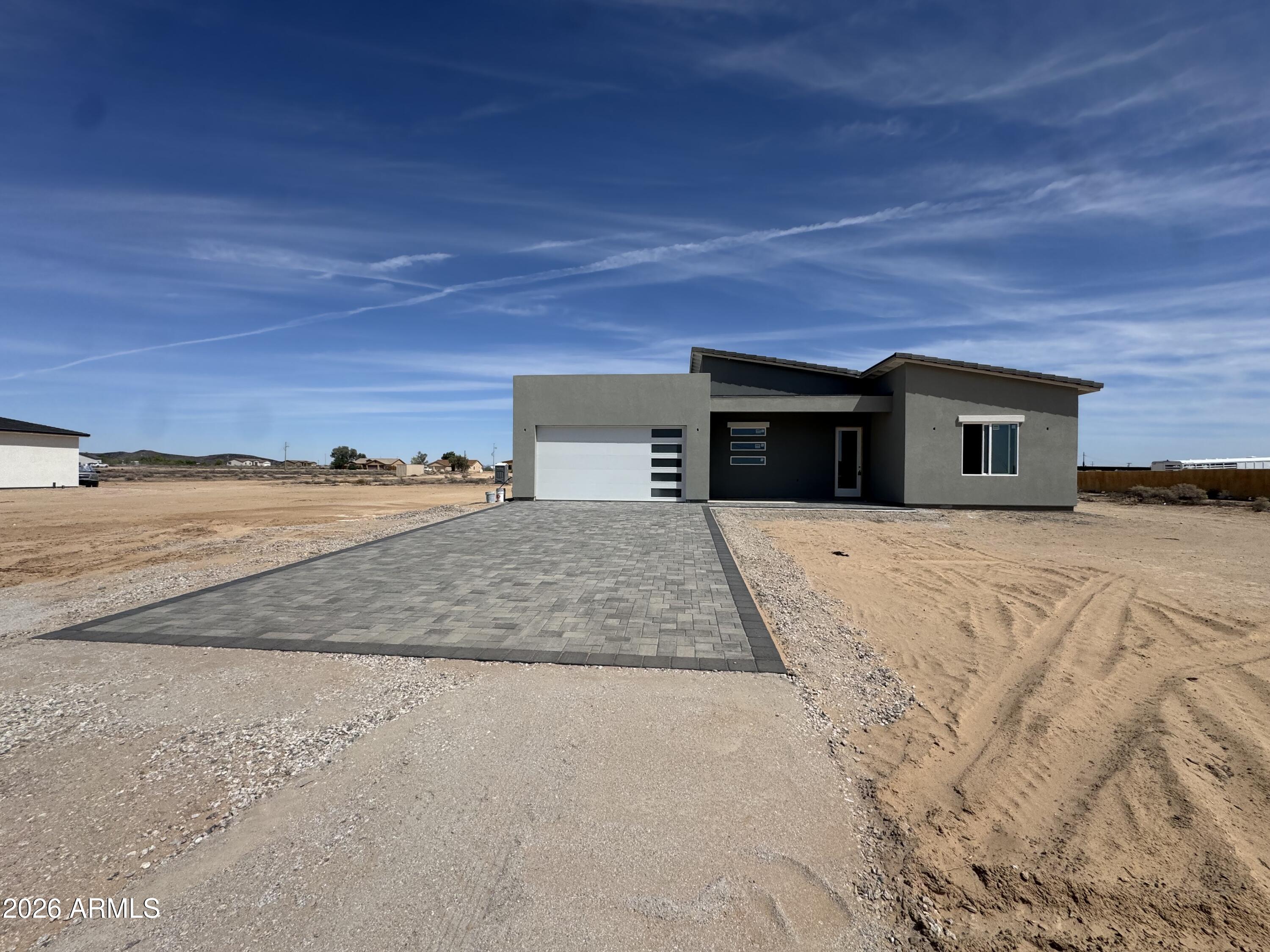 Modern desert Tonopah contemporary custom new-build on a full 1.25 acre lot.  Upscale finishes and open desert views among the many amenities this beauty brings!  The property features vaulted ceilings, beautiful tile flooring, quartz countertops, stainless steel appliances, paver driveway and new shaker cabinets.  Also a spacious kitchen with a large kitchen island, split floor plan, covered patio and plenty of room for RVs, horses or a future workshop.  The master has a separate entrance to the covered patio with walk-in shower and oversized master closet.   Very efficient home with spray foam throughout, high efficiency windows and synthetic stucco.   Great opportunity to own a home on acreage and no HOA!