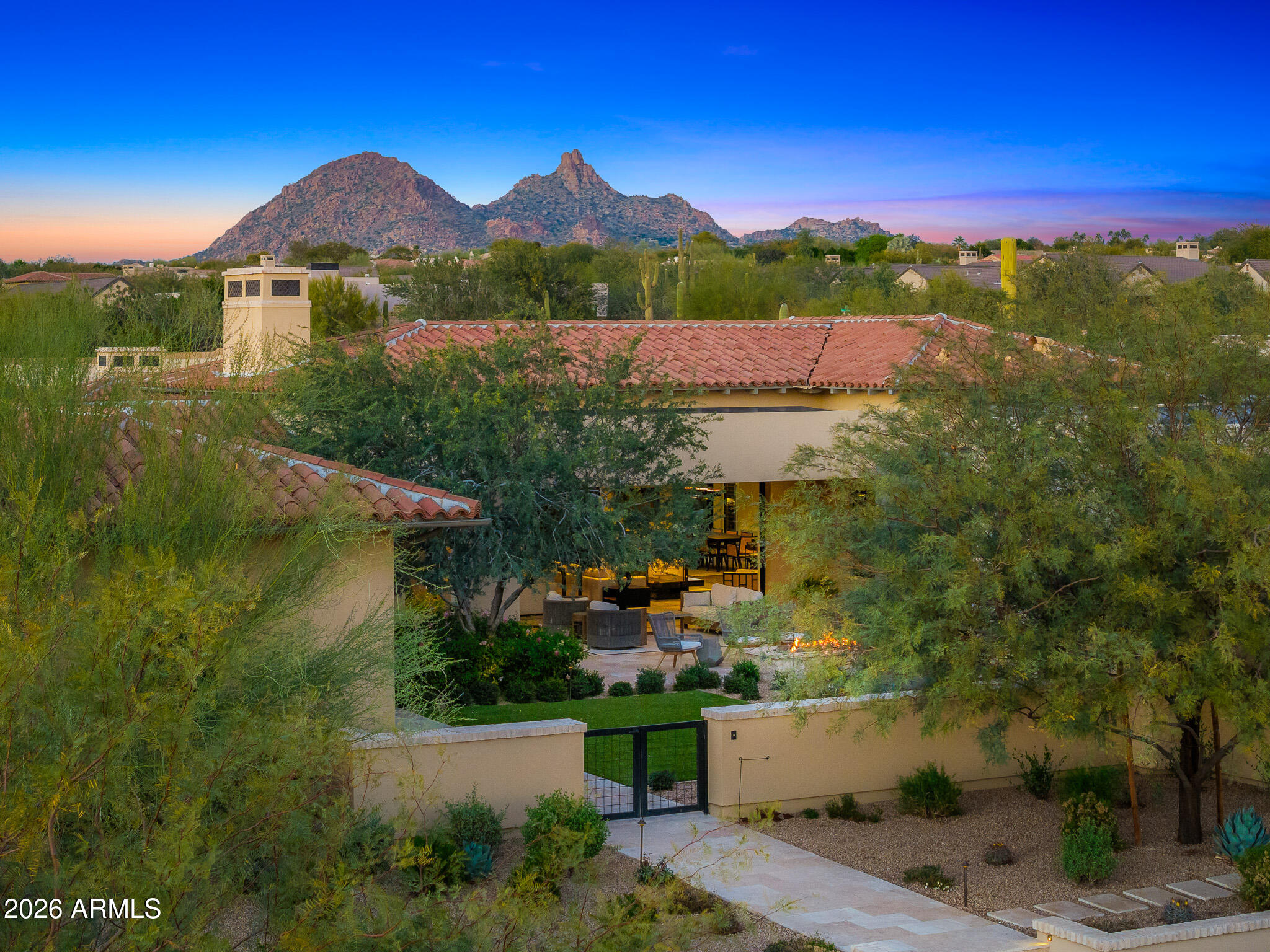 Welcome to White Horse, Scottsdale's top gated luxury community. A serene front courtyard sets the tone, featuring mature trees, a cozy fireplace, and inviting spaces for outdoor dining and entertaining. Step through the grand front vestibule into a stunning great room where open-concept living takes center stage. A statement fireplace anchors the space, while sliding glass doors on both sides capture views of the tranquil courtyard in front and the sparkling backyard pool beyond--creating seamless indoor-outdoor flow. The chef's kitchen is both beautiful and functional, offering a large island with gas cook top, high-end appliances, walk-in pantry, and a charming breakfast nook ideal for everyday living. The private primary suite overlooks the backyard and serves as a true retreat, complete with a massive walk-in closet and a spa-like bathroom featuring dual vanities, a private water closet, an oversized walk-in shower, and a luxurious soaking tub. Three generously sized guest bedrooms, each with its own en-suite bathroom, line the guest wing of the home, along with a versatile bonus room perfect as a TV lounge, game room, or relaxed guest retreat. The backyard is designed for entertaining, highlighted by a beautiful pool and a pool house ideal for hosting and lounging. The bonus casita (no bathroom) boasts a full size golf simulator. Don't forget about the money saving 84 solar panels! Refined, welcoming, and impeccably designed, this White Horse residence offers timeless elegance in one of North Scottsdale's most coveted gated communities.