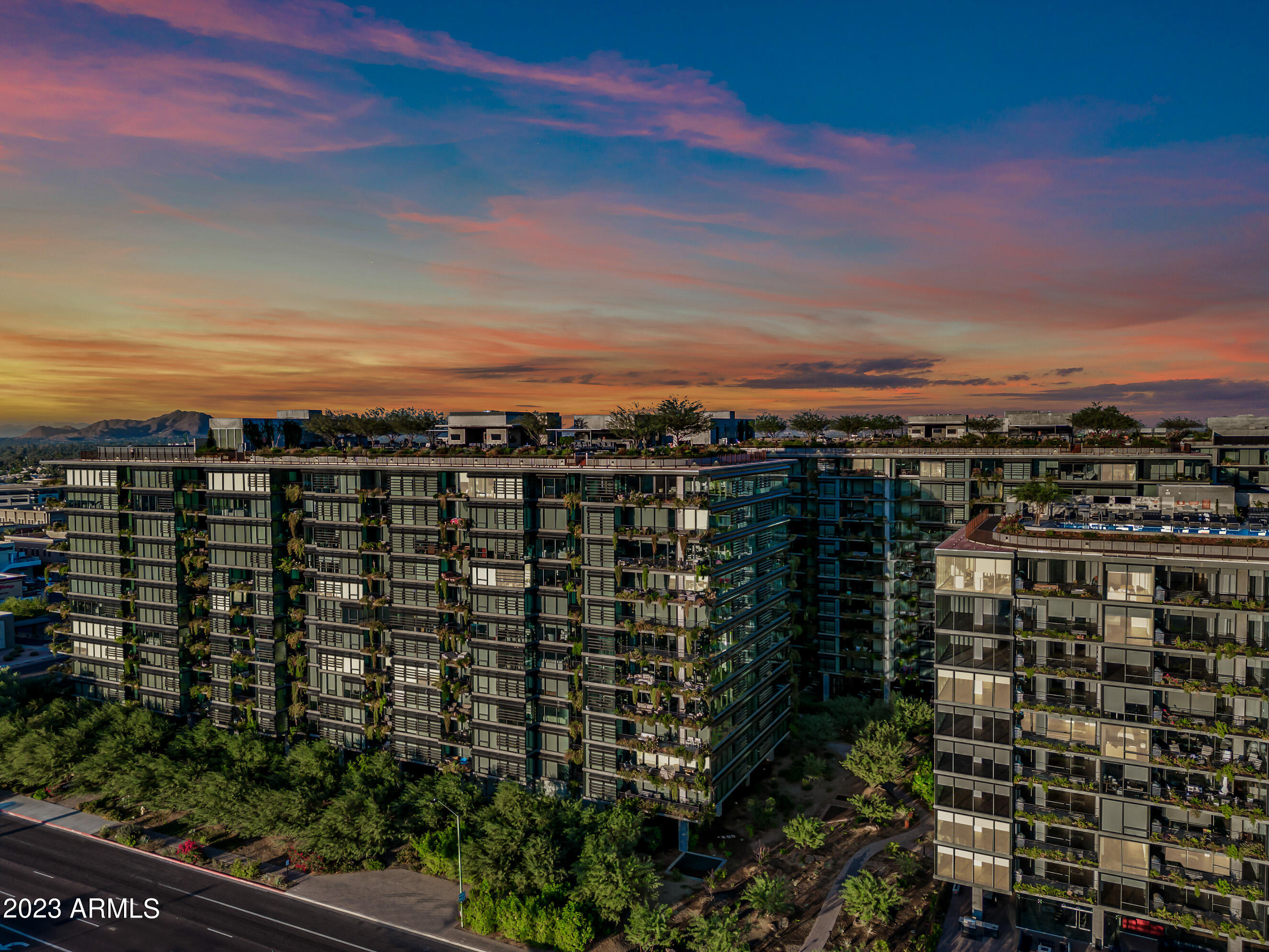 Welcome to OPTIMA KIERLAND, this exceptional corner unit includes a 12th floor PENTHOUSE with Floor-to-Ceiling windows on BOTH the East and North-facing sides, with breathtaking Mountain Views, City Lights, and a Skyline that will leave you in awe! This exclusive location ensures that you can keep your window coverings open all day w/o the scorching SW rays!  Inside, this spacious open floor plan is sleek, with modern finishes creating a contemporary oasis of style and comfort. This split plan penthouse, comes with 2 master suites with double sinks & walk in closets. AND, this rare find even has a third bedroom, and a third bathroom. The first master suite is a sanctuary in itself, with a separate sitting area that can be completely enclosed for privacy. This versatile space is perfect for an in home office, or a sitting area with mountain views and morning sunrises. 
The custom re-designed kitchen by the current owners features spacious granite countertops, a gas cooktop, and additional cabintery, as well as a quartz island, making it a dream for entertainers.  A sliding glass door seamlessly connects you to the patio, where you can enjoy the outdoor weather and views, with a fire pit and BBQ grill (gas hookups only) 
The premier lifestyle amenities offered here are nothing short of spectacular! Imagine taking a dip in the rooftop lap pool, rejuvinating in the sauna and cold plunge, or honing your skills on the indoor Pickleball and Baskeball courts.  
Golf enthusiasts will be delighted by the State-of-Art Golf Simulator, while fitness enthusiasts can enjoy a World Class Fitness Center and a tranquil massage room, or a yoga workout in the rooftop yoga room.
Enjoy a BBQ on the rooftop with family or friends, utilizing the outdoor kitchen, TV screens, fire pits, sitting areas and dining tables. Then play a game of ping pong or pool in the lounge area.   
For your convenience, there's even a coffee bar offering complimentary lattes to kickstart your day.  When you are ready to explore Scottsdale's finest shops, restaurants, and entertainment, you will find them just steps away from your penthouse, making this location second to none.  Don't miss this chance to experience the pinnacle of luxury living in the heart of North scottsdale across the street from Kierland Commons, and Scottsdale Quarter. 
A storage unit, and 2 (level 1) garage parking spaces included
