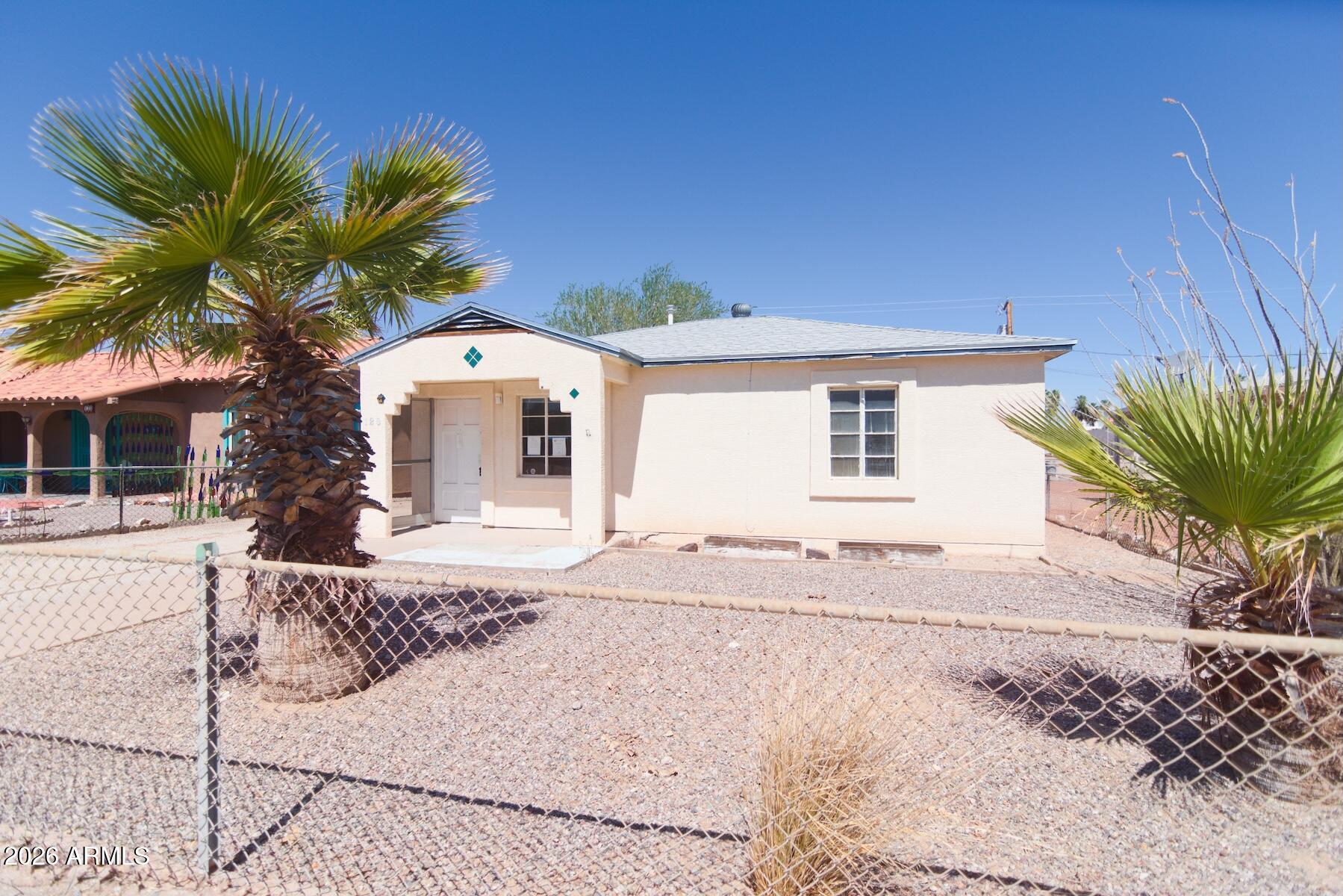 Welcome to this 2-bed, 1-bath home in the heart of Ajo, situated on a generous 0.15-acre lot with mature trees and wide-open backyard space. This 837 square foot single-story home features a detached garage with workshop area, covered patio for outdoor living, fenced yard with ample storage potential, and rear alley access.
Located just three blocks from iconic Ajo Plaza, you're a short distance to shops, dining, post office, and library. The property serves as a gateway to Organ Pipe Cactus National Monument, making it ideal for outdoor enthusiasts.