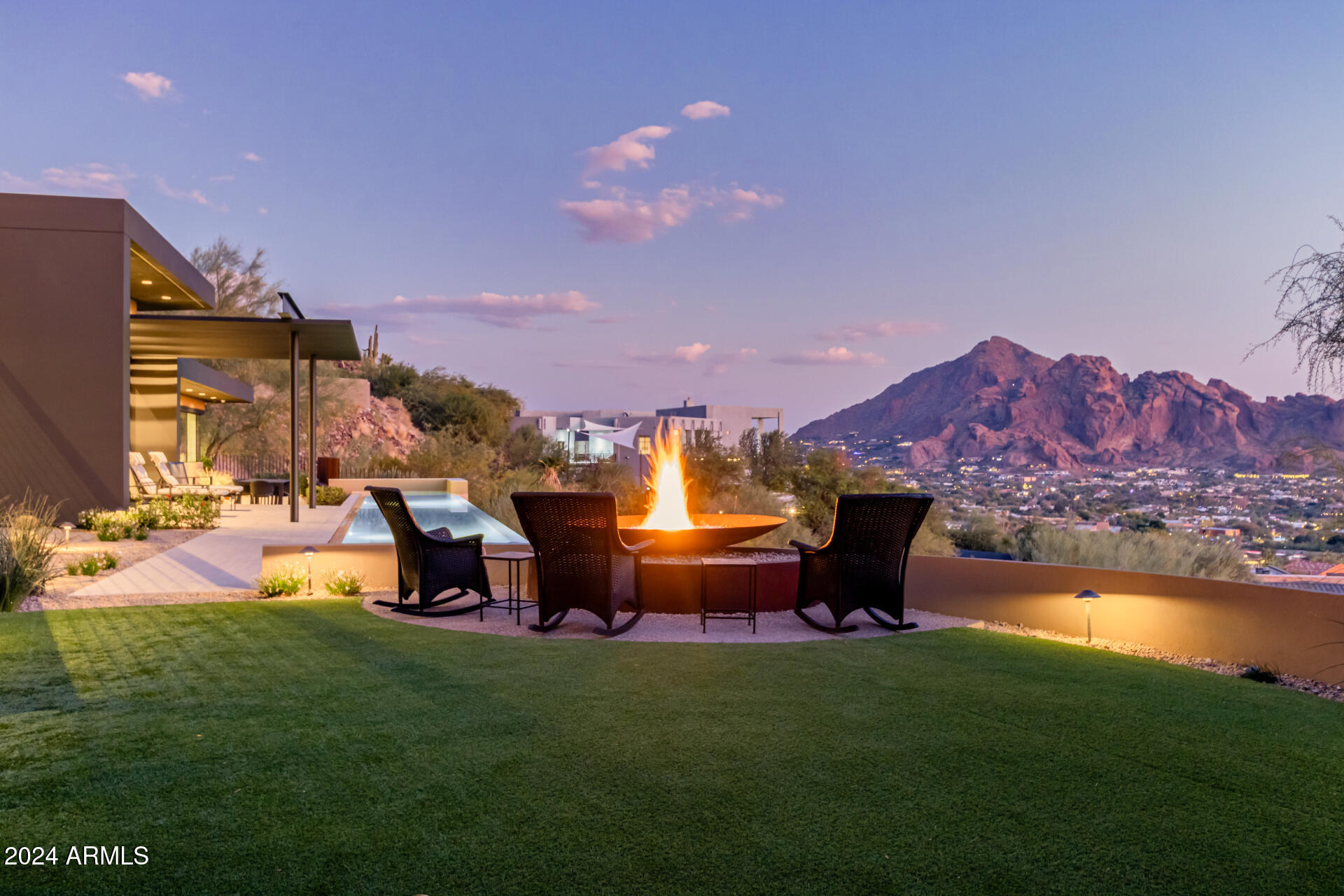 Nestled on 4 private hillside acres, this luxury Paradise Valley estate offers breathtaking panoramic views of Camelback Mountain, Papago Mountain & South Mountain. From the moment you arrive, the property invites you to experience its rare privacy, shielded from the street and stretching to the top of the hill. Rebuilt in 2007 with superior masonry construction by the highly acclaimed Construction Zone, the home combines strength and sophistication. 
The open design features an elevator, endless balconies and parking for up to 12 vehicles. Entertain effortlessly with a Chef kitchen, 75-foot heated lap pool, spa, outdoor firepit & putting green all framed by stunning Arizona sunsets. This is Paradise Valley living at its finest.