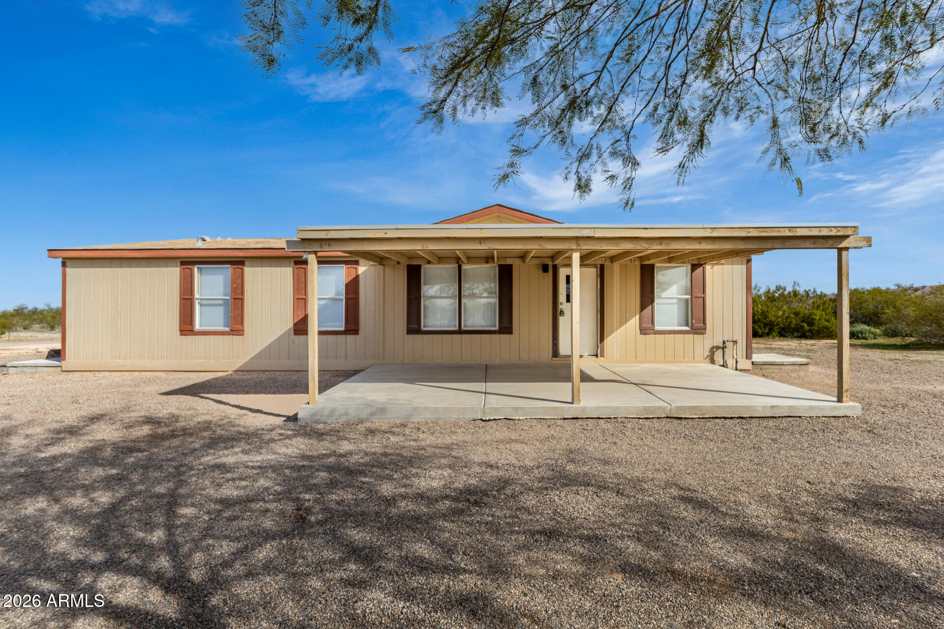 Welcome to Florence Homestead, the electronic gate welcomes you to this fully fenced horse friendly compound! Situated on 1.28 acres in Florence, AZ, this 1998 manufactured home offers 1,296 square feet of comfortable living space with 3 bedrooms and 2 bathrooms. The open great room floor plan provides a functional layout for everyday living and entertaining. The kitchen features granite countertops and flows into the main living area, while tile flooring throughout adds durability and easy maintenance. Zoned as horse property, the expansive lot offers plenty of space for animals, RVs, trailers, workshops, or future improvements. Enjoy privacy, open desert surroundings, and the freedom of rural living with convenient access to town amenities.