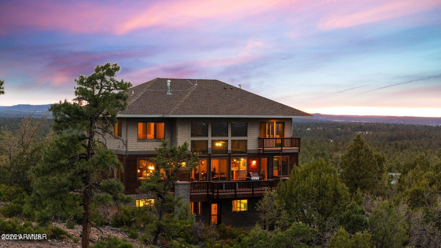 VIEWS, VIEWS & MORE VIEWS - The High Point of Show Low
Perched at the top of Show Low, this architect-designed custom home captures some of the
most breathtaking panoramic views in the White Mountains. On crisp winter days, you can
see all the way to the San Francisco Peaks in Flagstaff. To the north, enjoy sweeping views of
the forest, the town of Show Low, and even the wind turbines beyond Snowflake. From the
expansive back deck, take in stunning vistas of Porter Mountain, Mount Baldy, Blue Peak,
and surrounding White Mountain ranges.
Designed with three levels to maximize the scenery, this thoughtfully crafted home blends
comfort, craftsmanship, and functionality.
MAIN LEVEL
The main floor features an open-concept kitchen with custom maple cabinetry, a 10-foot granite island, perfect for entertaining or everyday cooking. A new LG combination oven/microwave includes a dividable oven that allows for three separate baking temperatures at once. Two cabinet-depth French-door refrigerators sit side-by-side, offering exceptional storage space.
The kitchen and dining area flow into a dramatic great room with soaring 20-foot ceilings, walls of glass, and a stunning elk antler chandelier. A stone fireplace with gas logs and thermostat control is crowned by a massive juniper log mantel and framed by custom built-in maple bookshelves.
Also on this level is a spacious study/den featuring a second stone fireplace with a juniper mantel, creating a warm and inviting retreat. The two-story entry foyer welcomes guests with a beautiful whitetail antler chandelier, celebrating the deer and elk that frequent the 1.11-acre property.
A stylish powder room completes the main level with a custom Michael Hays vessel sink, granite countertop, Antelope Ranch lighting fixture, and David Marsh mirror.
UPPER LEVEL
Upstairs are three bedrooms with spectacular views, plus a full guest bath featuring a Jacuzzi soaking tub.
The primary suite is positioned for privacy and comfort and includes a Vermont Castings wood stove with gas logs and thermostat, perfect for cozy mountain evenings. The ensuite bath offers a two-person Jacuzzi whirlpool tub with built-in heater, glass-enclosed shower, dual vanities, a private toilet room, and a spacious walk-in closet.
The entire upper floor and staircase feature new carpet with premium padding, while both bathrooms showcase new wood flooring with waterproof polymer backing. A conveniently located laundry closet with Maytag stacked washer and dryer sits just outside the primary suite.
LOWER LEVEL
The walk-out lower level includes a three-car garage with extensive shelving, along with a large living or recreation room and a fourth bedroom with its own half bath and oversized walk-in closet with built-in cabinetry.
An additional flex room offers excellent potential as a workshop, hobby space, or kitchenette for a future mother-in-law suite. It already includes cabinetry, a stainless-steel sink, and multiple power outlets, with plumbing roughed-in to expand the bedroom bath with a shower if desired.
Additional Features
This home is equipped with numerous thoughtful upgrades including:
Rinnai on-demand tankless water heater with circulation system, controllable via smartphone


Hybrid water softener with whole-house charcoal filtration system


Lightning protection system installed by a Lightning Institute of America-certified company


Whole-house surge protector


Hardwired monitored security system with smoke/heat detection and cellular dial-out


Gas hookup on the back deck for a barbecue


Unforgettable Setting
On the Fourth of July, this home becomes one of the best vantage points in town for the Show Low fireworks show. Skip the crowds and enjoy the celebration from your own elevated deck with family and friends while taking in the incredible panoramic scenery.
A truly one-of-a-kind mountain property combining stunning views, quality craftsmanship, and exceptional comfort in one of Show Low's most desirable locations.