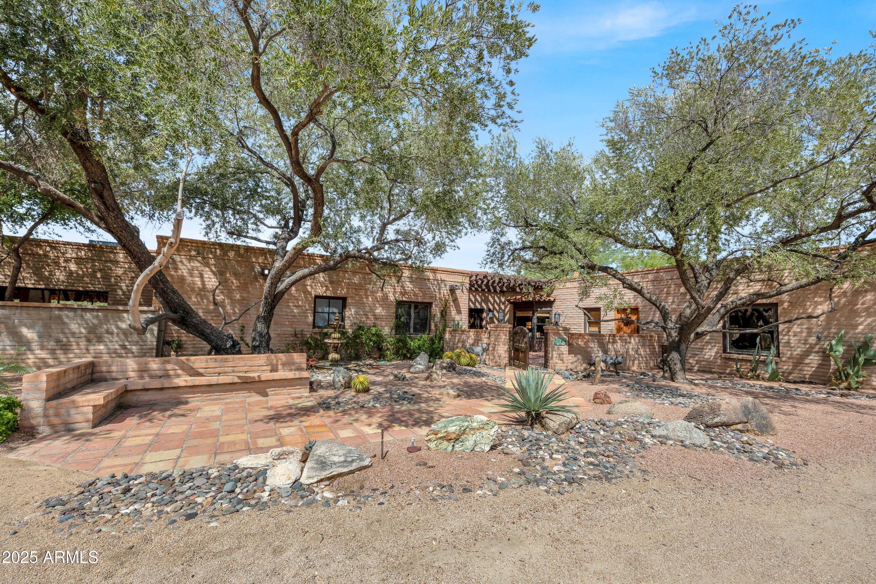 Rare opportunity to own on the east side of Cave Creek, adjacent to Preserve land! This 5-acre property offers tall shade trees, corral and turnout areas, fenced garden/orchard, and tack room storage. The Hacienda-style main home is complemented by a spacious casita with full kitchen, living room, fireplace, dining area, and private driveway—ideal for guests or income potential. Gated entry, paved road, and a highly desirable location make this property truly special.