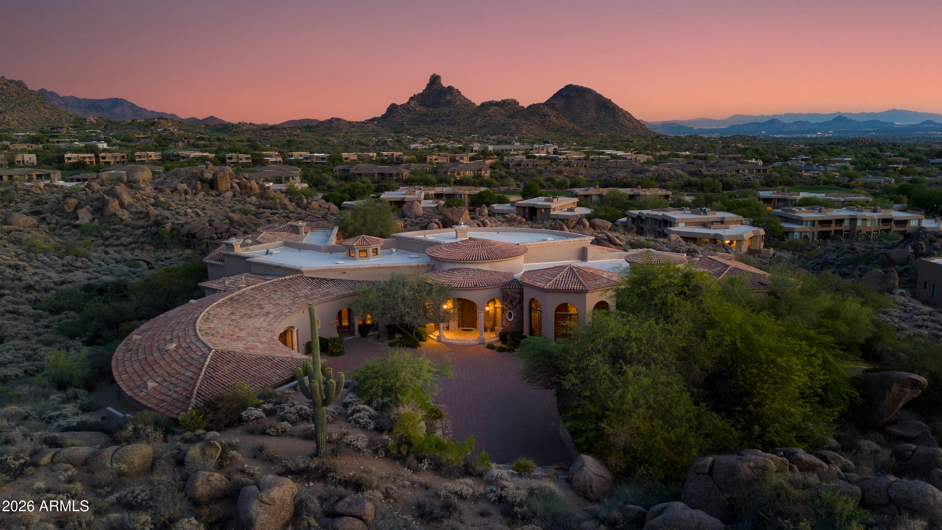 Views, views, views! Perched atop 4.9 private acres in the renowned Troon North Talus community, this 7,875 sq. ft. custom estate captures sweeping panoramic Sonoran Desert views and exceptional privacy. Built for the original owner, the home offers 4 bedrooms, 4.5 baths, including an attached casita. Interior features include soaring ceilings, Venetian plaster, hand-carved wood beams, a grand great room with 15' custom doors opening to the back patio, formal dining with wet bar, wood-paneled media room, private office, and expansive kitchen/living with 3 islands. Outdoors enjoy a resort-style pool and spa surrounded by the beauty of the high desert. The 4-car garage plus 2 lifts accommodates up to 6 vehicles. A rare opportunity in one of North Scottsdale's most prestigious communities.