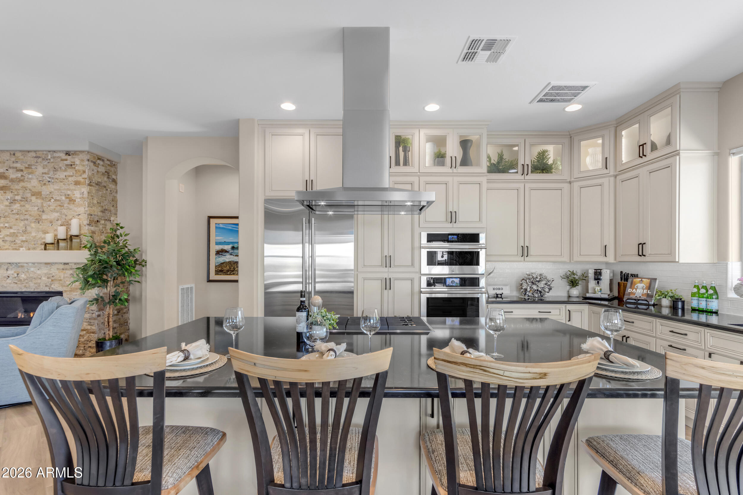 Serene golf course and lake views are the backdrop for this like-new, open-concept, 3 car garage, Captivate floor plan (2BD, 2.5BA + Den). Set on a premium corner homesite with no immediate neighbors behind, this residence enjoys abundant natural light & makes a dramatic statement from the moment you step inside w/ exceptional designer upgrades showcased at every turn. Gourmet kitchen impresses w/ soaring ceiling-height cabinetry, JennAir appliances, built-in refrigerator, gas cooktop, & quartz countertops. Tile plank flooring flows seamlessly throughout, while the great room is anchored by a custom stacked-stone fireplace. Den showcases a built-in desk and bookcase. Outdoors, the backyard retreat features extended travertine hardscaping & a built-in gas firepit, perfect for relaxing. Construction began on this custom home in 2023 and it was completed December, 2023. The sellers moved into the home in 2024. This home is only gently lived in for the last two years, meticulously maintained and is therefore in like-new condition. The ceiling height kitchen cabinetry and the custom floor-to-ceiling stacked stone fireplace make a remarkable impression from the moment you walk into this home. The spacious primary suite offers a luxurious retreat featuring dual vanities, walk-in shower with floor-to-ceiling decorator tile, Hall of Frames mirrors, Moen Matte Black fixtures including handheld shower with slidebar  and oversized walk-in closet. Designed with a desirable split floor plan, the home also features a generously sized guest suite complete with an ensuite bath with a tile tub surround.  Additional enhancements include a well appointed half bath,  Smart Space laundry with full cabinetry, quartz counters, stainless steel sink, and dual work stations, along with designer lighting, 16 additional recessed ceiling lights, Saratoga glass front door, courtyard pavers, two-tone paint, windowsills, soft-close kitchen cabinetry with pull-out shelving, recycle center, upgraded window treatments, water softener, reverse osmosis system, and a three-car garage with epoxy flooring and garage insulation. The extensive list of thoughtful enhancements continues throughout the home.
The community is well-known for the award-winning, private Tom Lehman designed Golf Course. It has every amenity imaginable: pickleball, tennis, bocce, state of the art health & fitness center, Alvea Spa, just to name a few. The list of community activities is never-ending: concerts, classes, social clubs, car shows, events and much more. Eateries include: La Palma (the signature restaurant, in a beautiful atmosphere with panoramic views), Bodega Wine and Café (for small plates and wine tasting), and the Solaz and Algarve pool Grills. There are four pools to enjoy. The Solaz pool sits adjacent to the golf course with stunning views. The Algarve, the adult-only pool, is perfect for a little added relaxation. Join the Fun and the Good Life at Encanterra!