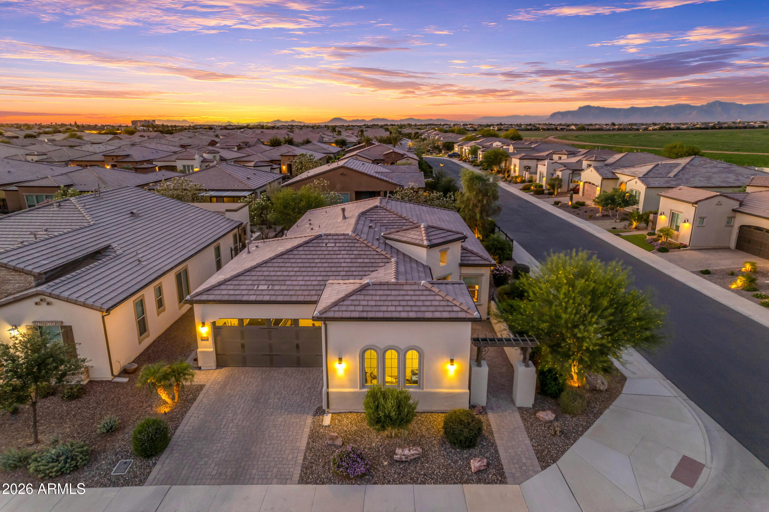 Serene golf course and lake views are the backdrop for this like-new, open-concept, 3 car garage, Captivate floor plan (2BD, 2.5BA + Den). Set on a premium corner homesite with no immediate neighbors behind, this residence enjoys abundant natural light & makes a dramatic statement from the moment you step inside w/ exceptional designer upgrades showcased at every turn. Gourmet kitchen impresses w/ soaring ceiling-height cabinetry, JennAir appliances, built-in refrigerator, gas cooktop, & quartz countertops. Tile plank flooring flows seamlessly throughout, while the great room is anchored by a custom stacked-stone fireplace. Den showcases a built-in desk and bookcase. Outdoors, the backyard retreat features extended travertine hardscaping & a built-in gas firepit, perfect for relaxing. Construction began on this custom home in 2023 and it was completed December, 2023. The sellers moved into the home in 2024. This home is only gently lived in for the last two years, meticulously maintained and is therefore in like-new condition. The ceiling height kitchen cabinetry and the custom floor-to-ceiling stacked stone fireplace make a remarkable impression from the moment you walk into this home. The spacious primary suite offers a luxurious retreat featuring dual vanities, walk-in shower with floor-to-ceiling decorator tile, Hall of Frames mirrors, Moen Matte Black fixtures including handheld shower with slidebar  and oversized walk-in closet. Designed with a desirable split floor plan, the home also features a generously sized guest suite complete with an ensuite bath with a tile tub surround.  Additional enhancements include a well appointed half bath,  Smart Space laundry with full cabinetry, quartz counters, stainless steel sink, and dual work stations, along with designer lighting, 16 additional recessed ceiling lights, Saratoga glass front door, courtyard pavers, two-tone paint, windowsills, soft-close kitchen cabinetry with pull-out shelving, recycle center, upgraded window treatments, water softener, reverse osmosis system, and a three-car garage with epoxy flooring and garage insulation. The extensive list of thoughtful enhancements continues throughout the home.
The community is well-known for the award-winning, private Tom Lehman designed Golf Course. It has every amenity imaginable: pickleball, tennis, bocce, state of the art health & fitness center, Alvea Spa, just to name a few. The list of community activities is never-ending: concerts, classes, social clubs, car shows, events and much more. Eateries include: La Palma (the signature restaurant, in a beautiful atmosphere with panoramic views), Bodega Wine and Café (for small plates and wine tasting), and the Solaz and Algarve pool Grills. There are four pools to enjoy. The Solaz pool sits adjacent to the golf course with stunning views. The Algarve, the adult-only pool, is perfect for a little added relaxation. Join the Fun and the Good Life at Encanterra!