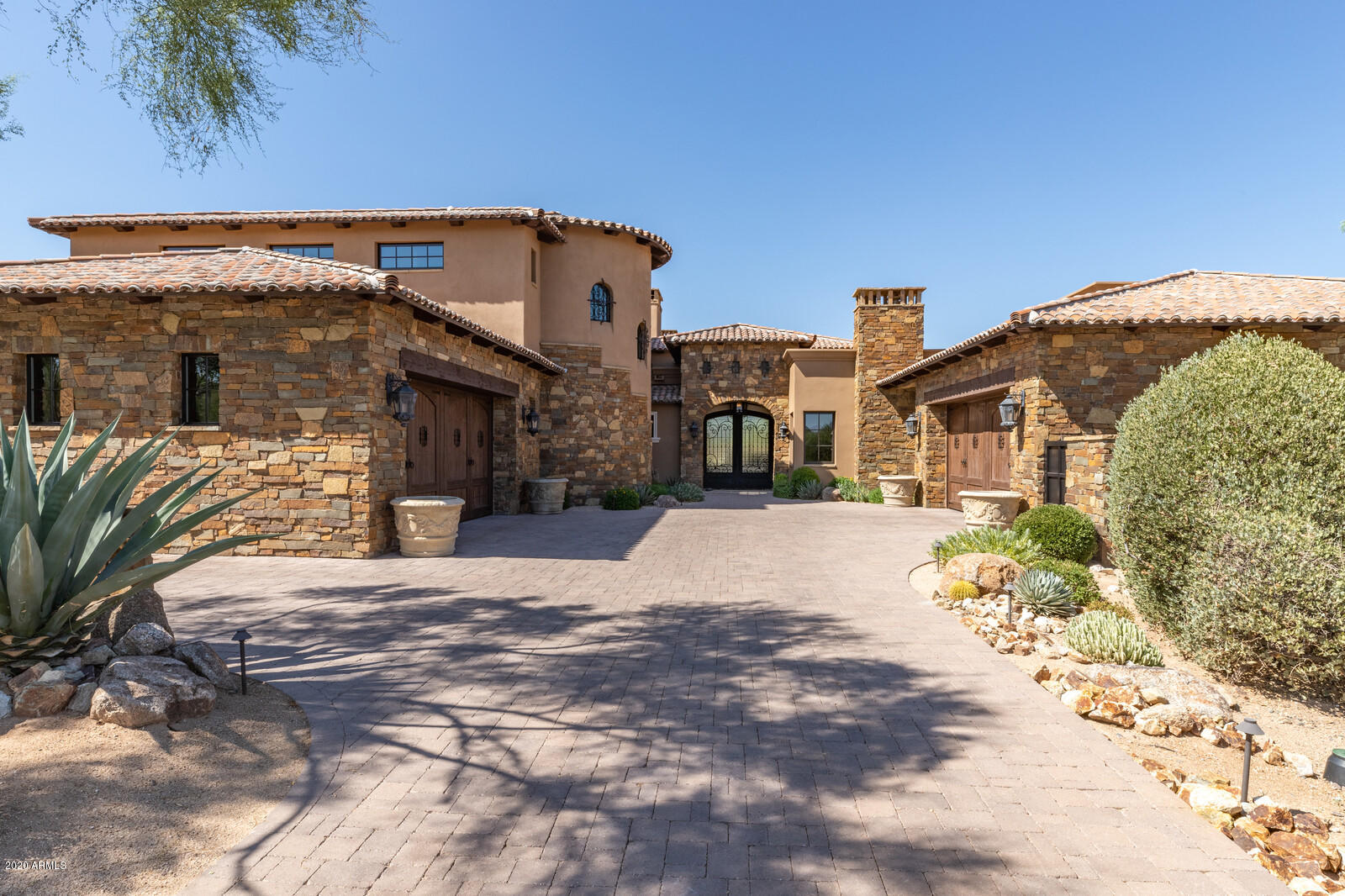 Situated in the guard gated golf course community of Estancia rests this like new elegant home. The 7,528/sf home includes 5 bedroom en-suites and a swank office also with it own full bath. You will love the opulent double island kitchen with adjacent breakfast room overlooks the great room and includes Wolf and Subzero appliances, walk in pantry and wine closet. The adjacent Great room includes an elegant fireplace and glass pocket doors opening to the double negative edge pool, spa, fountain, fire pit and outdoor fireplace. The lavish master suite sports unique ceiling treatment, fireplace, aroma therapy mist and lit tub, his and her closets with fine cabinetry and its own washer & dryer. Also included is a spacious game room as well as a theater room. The formal dining room is graced... with a rustic bricked groin ceiling, elegant fireplace and an adjacent butlers pantry with ice maker and dishwasher. The home includes only the finest finishes, beamed ceilings and hand scraped wood and Travertine flooring. Also included is highly finished laundry room, steam shower in the room used for fitness, covered patio, stone walls and accents and a 4 car garage.