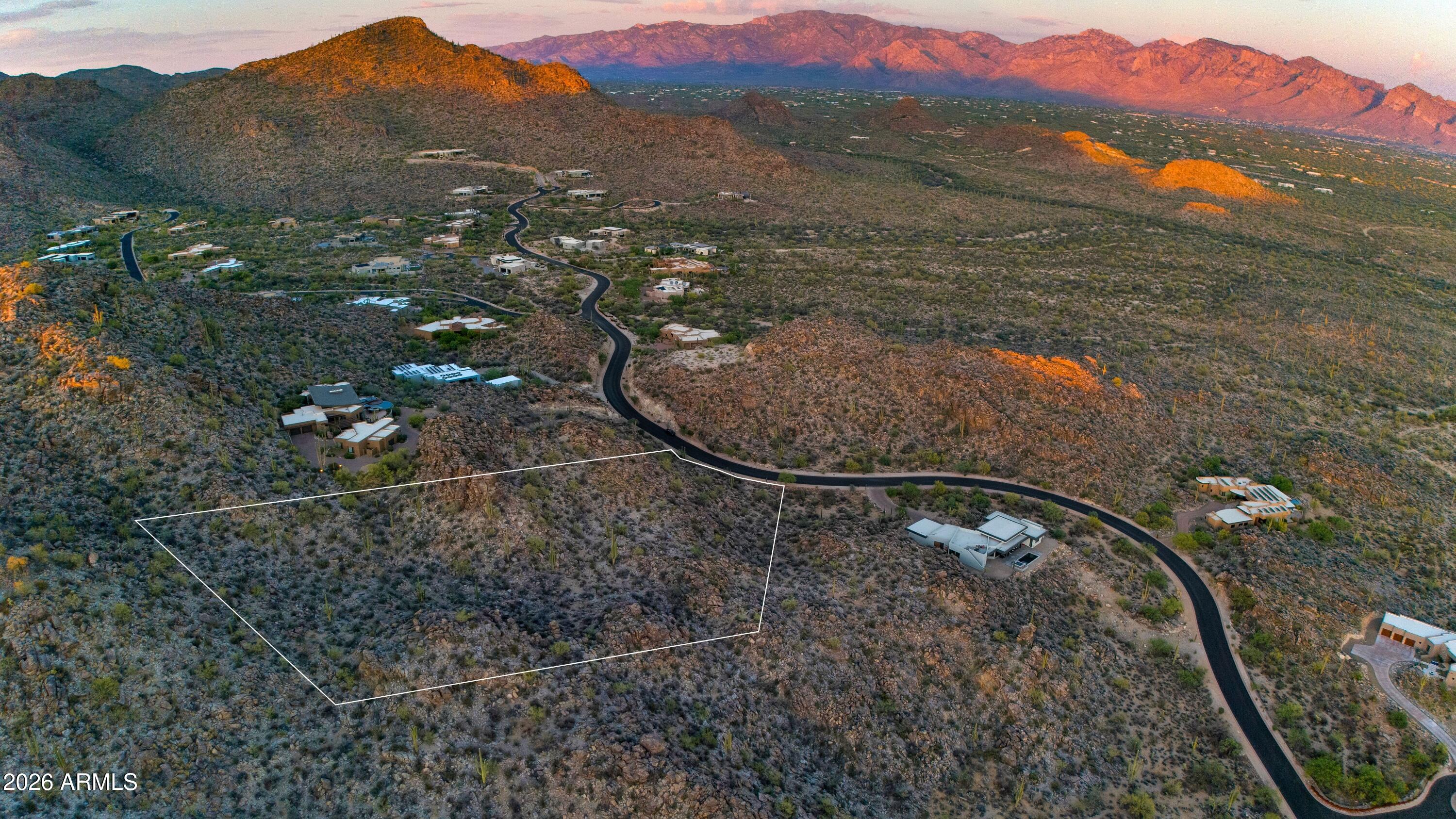 Perched high within the mountains of Dove Mountain's prestigious guard-gated Canyon Pass, this homesite offers a rare combination of elevation, privacy, and natural desert beauty. The elevated building envelope provides a dramatic vantage point with sweeping views, while massive natural boulders wrap the rear of the property, creating a stunning backdrop and exceptional privacy. Golf and social memberships are optional, giving owners flexibility in how they enjoy the community. Residents have access to a private restaurant, a recreation center with tennis and pickleball courts, and a lap pool.