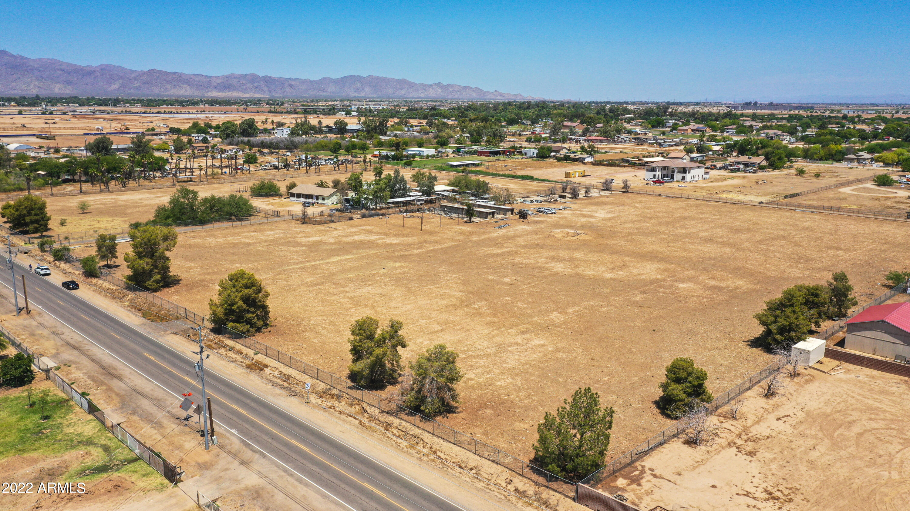 PRIME 303 Corridor Location!  Outstanding Potential for development in this high-growth area!  Less than a mile to State Route 303 with access to Taiwan Semiconductor Manufacturing Company (TSMC) In rapidly developing light industrial parks / commercial area.  Current industries include Amazon, Walmart, Best Buy, etc.  Near FedEx, UPS and truck bay rental space.  Two continguous lots totaling over 14.4 acres.  Parcels are 501-49-011E (9.6 acres) to be sold with adjoining lot 501-49-011E (4.8 acres). See MLS #6497576.

Please watch the included video about AZ Route 303 Industrial growth. Buyer responsibility to determine property usage option, see Section 1010 of Chapter 10 of the Maricopa Overlay Zoning Ordinance  (attached in the documents section) regarding land usage. Shared septic. Concrete irrigation ditch at north side and county maintained drainage ditch on south side.  Adaman commercial plumbing for residential use at front of property. Electricity / transformer on common property line. No access to house.  Buyer responsibility to determine property usage options and whether new residence may be built on property.  Property includes dog kennel slab.  No fencing on west side.