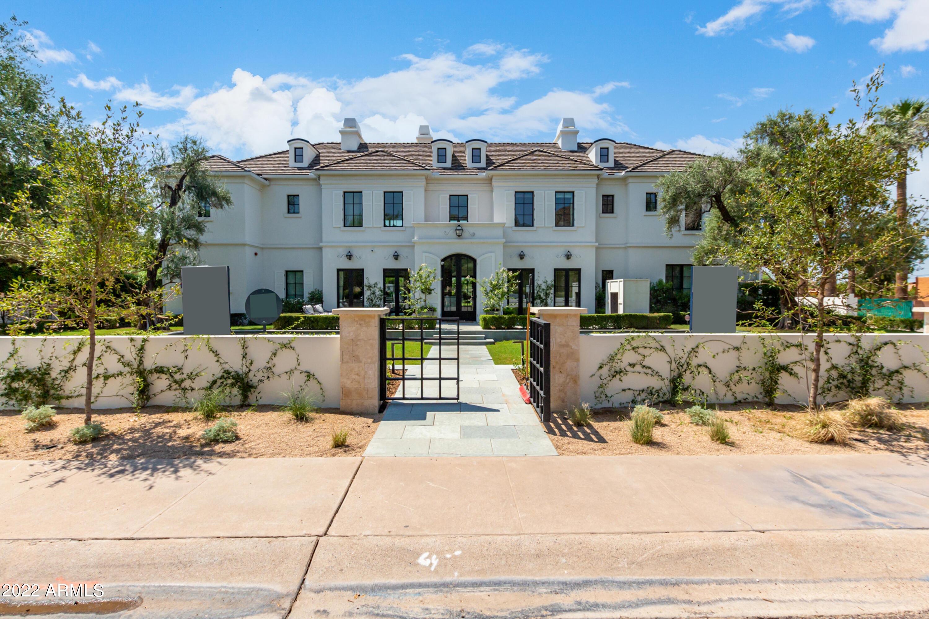 Nestled along one of Arcadia Proper's most coveted streets, this exceptional over ½ acre custom estate by Brimley Development offers Camelback Mountain views and nearly 7,000 square feet of timeless Hamptons-inspired design, elevated by renowned LA designer Jess Diab and featured in Lux Magazine. Located within the highly acclaimed Hopi School District, this 5-bed, 5.5-bath home also includes a private office, theater room, and thoughtfully curated living spaces designed for both grand entertaining and everyday luxury. Soaring ceilings, abundant natural light, designer-curated lighting, and an open-concept floor plan define the home's sophisticated yet inviting atmosphere. The expansive great room features a gas fireplace and a dramatic wall of sliding glass doors that seamlessly connect indoor and outdoor living. A formal dining room with a wine wall pass-through complements the stunning chef's kitchen, complete with premium appliances, custom cabinetry, an oversized eat-in island, breakfast room, and a butler's pantry. The resort-style backyard is a private oasis featuring a custom heated pool and spa with water features, built-in BBQ station, covered patio with misters, lush grass yards, and mature landscaping. Additional highlights include a bonus living room with wet bar, front patio with exterior gas fireplace, and a temperature-controlled extended 3.5-car garage with epoxy flooring and built-in storage. Perfectly positioned just minutes from Arcadia's favorite restaurants, luxury shopping, premier resorts, golf, and fine dining, this extraordinary residence delivers the very best of Arcadia living.