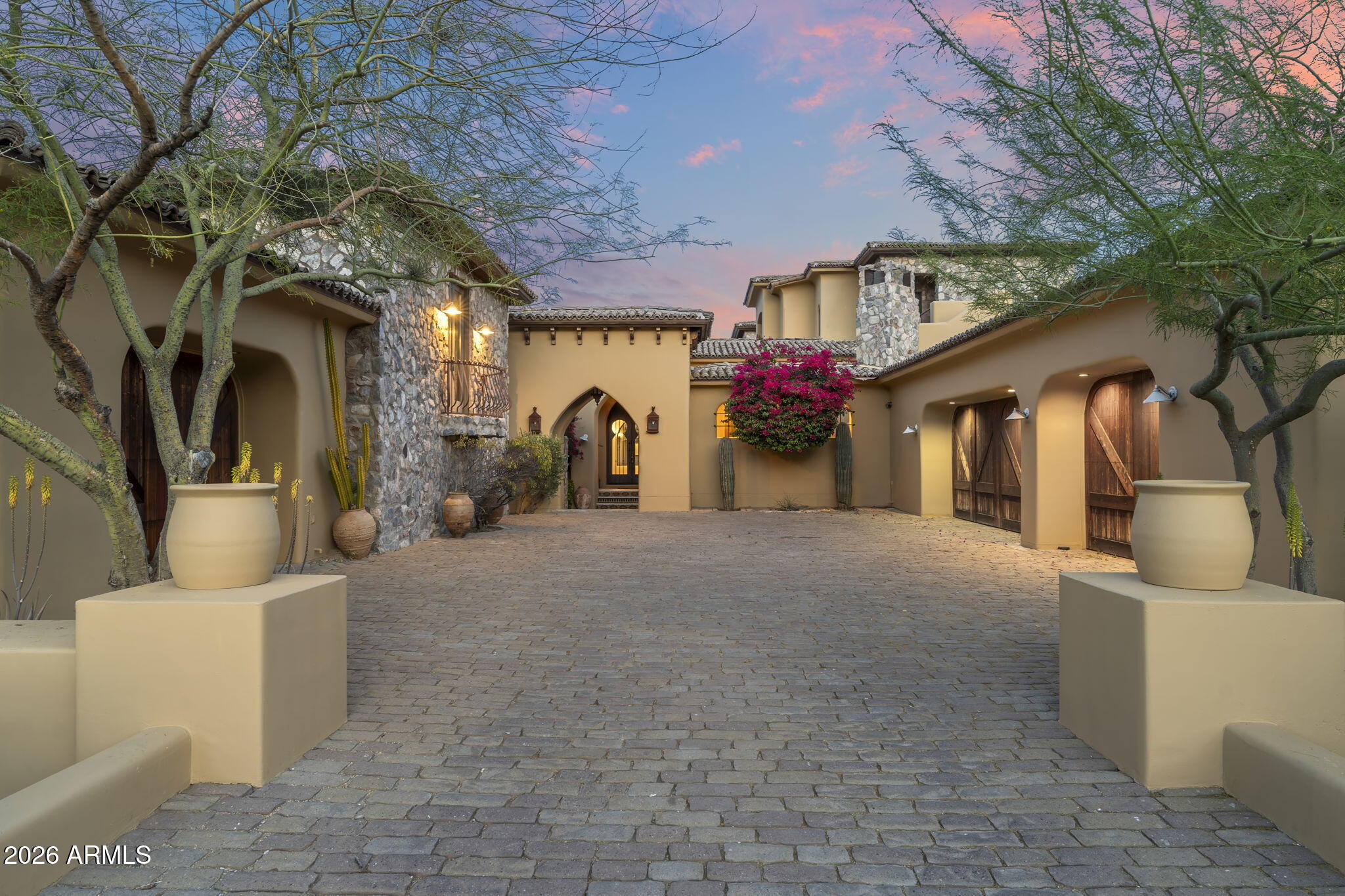 What does true privacy look like in Arizona luxury real estate? It looks like 6,800 square feet of elevated desert living, surrounded by the McDowell Mountain Preserve, with endless views and no city noise.
Welcome to a privately positioned estate in Fountain Hills, Arizona designed for those leaving crowded coastal markets and seeking space, quiet, and year-round sunshine. This 5 bedroom, 6 bathroom residence offers the scale, flexibility, and seclusion luxury buyers are actively searching for.
The main residence features expansive entertaining spaces including a formal dining room, oversized great room, dedicated office, game room, private theater, and two laundry rooms for effortless multi-generational living. A gourmet kitchen anchors the home, complemented by a discreet behind-the- scenes prep kitchen ideal for catered events, holiday gatherings, or extended stays with guests.
Each bedroom is generously sized with ensuite baths, creating hotel-style comfort for family and visitors. The primary suite offers the privacy and scale expected in a desert estate retreat.
Step outside to your resort-inspired backyard with a private pool framed by mountain views and natural preserve surroundings. Whether hosting sunset dinners or enjoying quiet mornings under the Arizona sky, this property delivers the indoor-outdoor lifestyle luxury buyers expect in the Northeast Valley.
A four-car garage provides ample space for car collectors, golf carts, or recreational vehicles.
The two-story guest house includes its own kitchen, bedroom, bathroom, and sitting area. Perfect for extended family, live-in staff, long-term guests, or executive remote work separation.
Located in the prestigious McDowell Mountain area of Fountain Hills, residents enjoy immediate access to hiking and mountain biking trails, world-class golf courses, Fountain Park, upscale dining, boutique shopping, and an easy drive to Scottsdale's luxury amenities. Buyers relocating from Los Angeles, Orange County, and San Diego are choosing Fountain Hills for larger lots, lower density, tax advantages, and unobstructed Sonoran Desert views.
Luxury homes with guest houses in Fountain Hills rarely combine scale, privacy, preserve adjacency, and proximity to Scottsdale in one offering.
For buyers seeking a private desert estate in Arizona with room to live, host, and retreat. This is the opportunity.