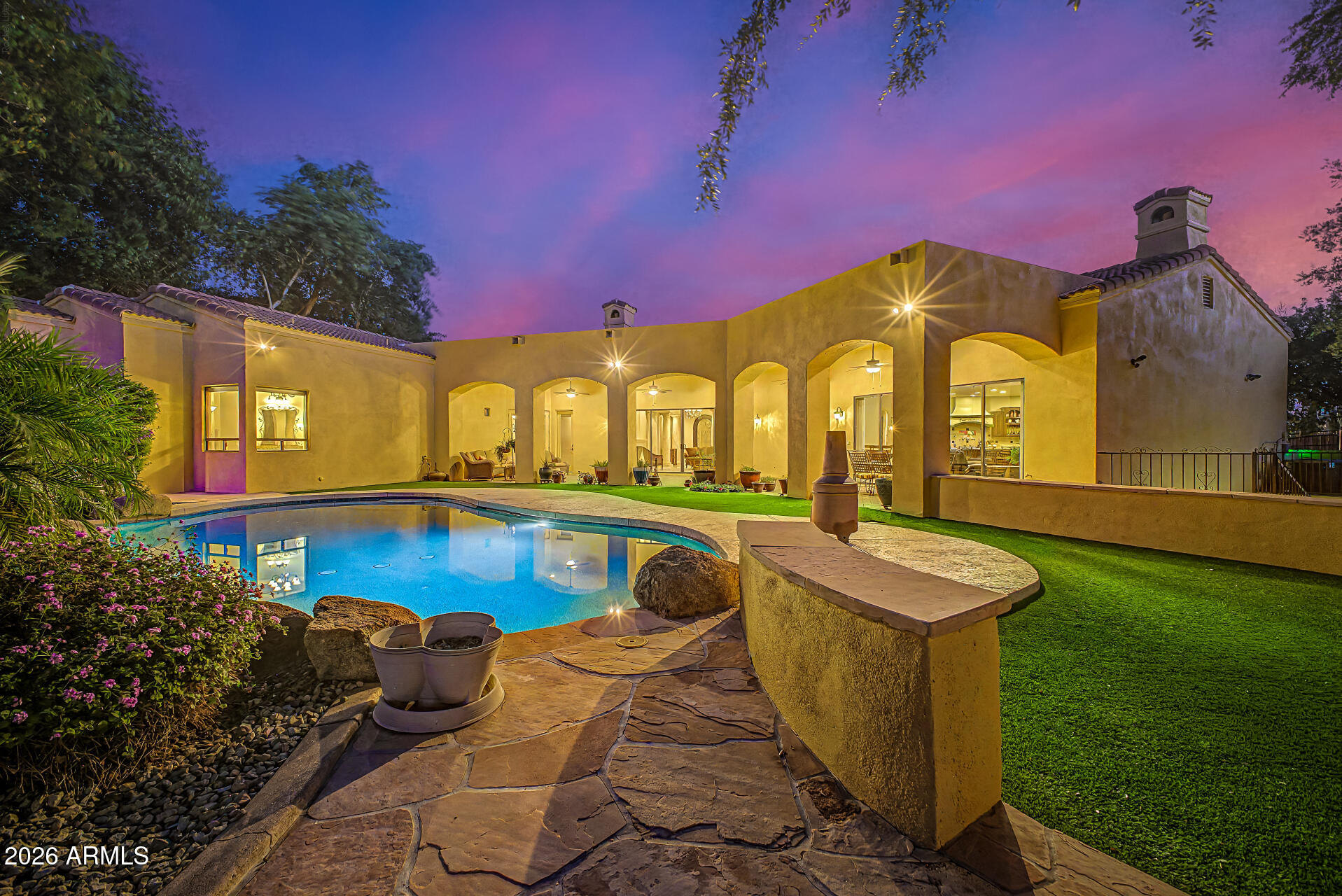 Stunning custom Tuscan Estate in NORTH PEORIA on OVER AN ACRE with NO HOA, WALKOUT BASEMENT, resort-style pool, putting green, and 900 sq ft shop. This 5,030 sq ft home offers 4 bedrooms, 3.5 baths, with seamless indoor & outdoor living designed for the Arizona lifestyle. From the moment you arrive, the circular driveway, lush mature landscaping, and private courtyard with dual fountains create a grand first impression. Inside, a dramatic foyer framed by solid concrete faux marble pillars draws your eye through the formal living space to the breathtaking backyard beyond. Walls of glass showcase a true outdoor retreat--complete with a custom pool & rock waterfall, expansive covered patio, outdoor fireplace, gazebo, and private putting green. Designed for both everyday living & entertaining, including whole-house sound system. The home effortlessly blends indoor & outdoor spaces. Four grand fireplaces anchor the home's living spaces-featured in the formal living room, family room, primary suite sitting area, and backyard-adding warmth, scale, and architectural presence throughout.
The gourmet kitchen features custom alder cabinetry, granite countertops, a large island with prep sink & built-in steamer, 6-burner gas cooktop, high-end Advantium and Trivection ovens, a warming drawer, and a custom walk-in pantry. It opens to the main living area, dining space, and a functional family connection station, all adjacent to a spacious laundry/utility room. The primary suite offers a sitting room with fireplace & patio access, along with a spa-inspired bathroom featuring dual vanities, two custom walk-in closets, Bain Ultra air-jet soaking tub, and dual-entry walk-in shower with tankless water heater. A secondary bedroom & full bath are also located on this wing. The fully finished walkout basement adds exceptional versatility with a large media room, custom built-ins, two bedrooms with large walk-in closets, full bath, storage, and private patio with direct backyard access. Additional highlights include a 900 sq ft shop with custom-built-in shelves, RV gate, whole-home water softener & RO system, travertine flooring, custom doors and cabinets throughout. A rare opportunity to own a private, resort-style estate in one of Peoria's most desirable areas.