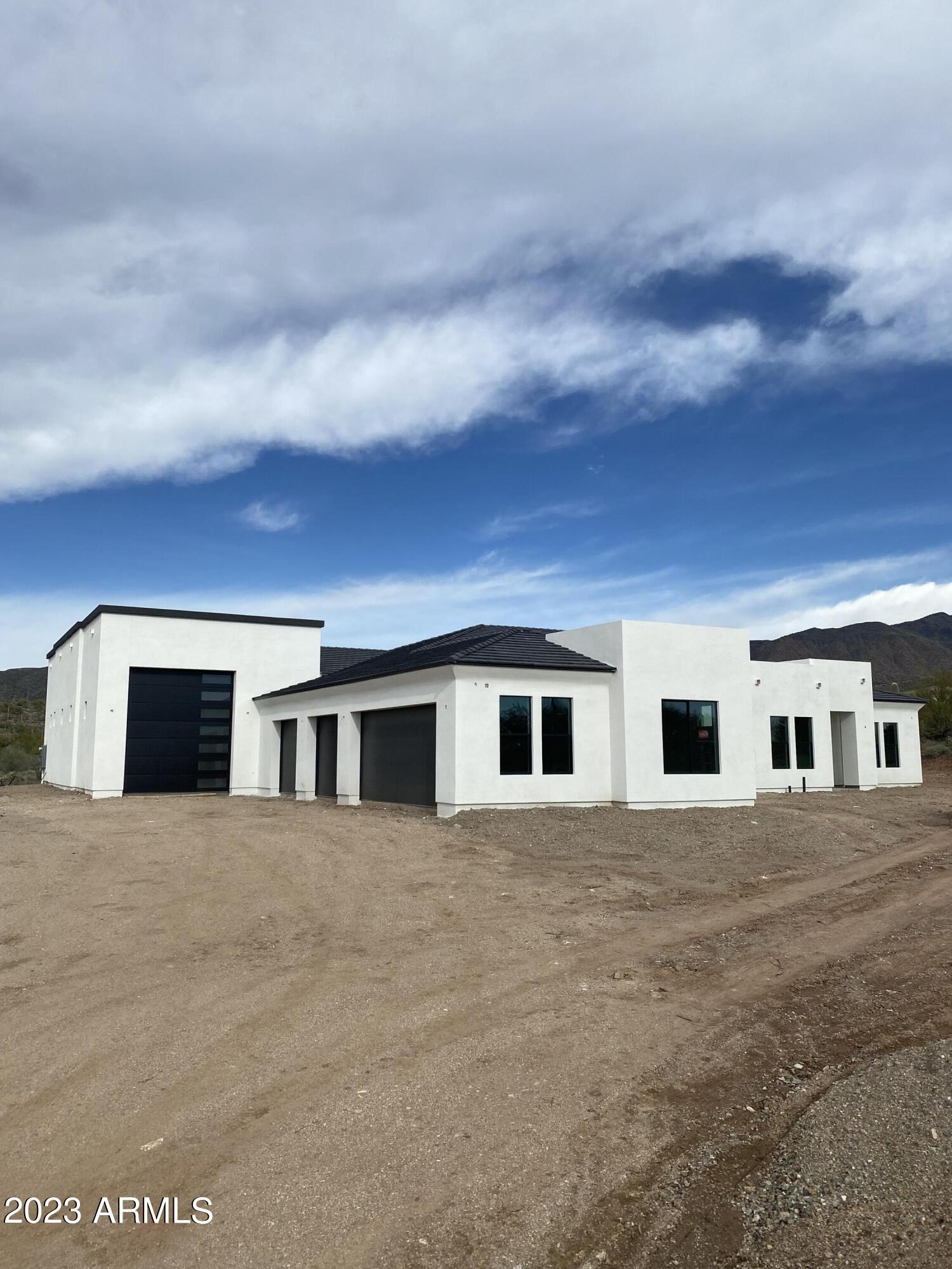 Much further along then the pictures! Getting close to completion! Amazing opportunity to be the proud owner of this modern construction newly built home sitting on a 4.5-acre lot! Single story 4 bed, 3 bath property with 2864 sq. ft. RV garage for all your trucks & toys + a 4 car garage! Fantastic modern floor plan with fabulous upgrades throughout, gourmet kitchen with upgraded appliance package, gas stove, vent hood, upgraded counter tops and cabinetry. Gorgeous flooring T/O.  Home abounds with bountiful natural light. Stunning mountain, sunset, & desert views from every room of your new custom home. Excellent Cave Creek location with lots of privacy and close to shopping, dining, & entertainment. Don't wait; this unique opportunity will not last! House colors, almost white on the body with black trim, grey roof, paver driveway, front yard landscaping.  Inside there will be gorgeous hardwood floors, 3cm quartz, mat black faucets, appliances with can fronts on them, stone on the fireplace.  More to come soon as we are getting closer to being finished with this amazing home!