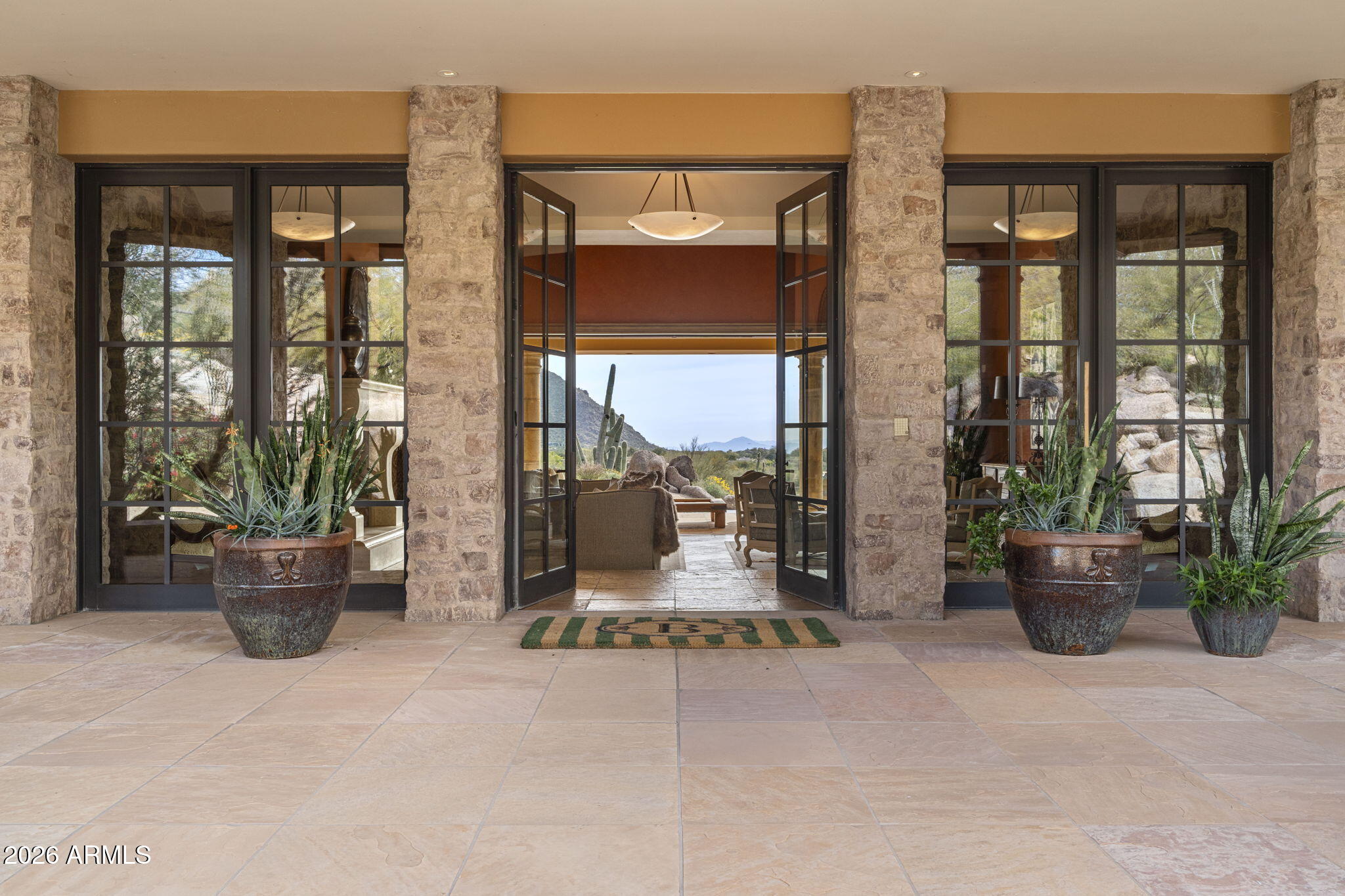 Unrivaled Views, Timeless Elegance in Talus at Troon North
A true trophy estate perched on one of the most coveted view lots in all of North Scottsdale. Located within the prestigious gated golf community of Talus at Troon North, this exceptional luxury custom home offers jaw dropping, panoramic views of city lights, Pinnacle Peak, Troon North Golf Course, vivid Arizona sunsets, and the surrounding Sonoran Desert mountains — all from one of the highest elevation lots in the area.  Boasting over 7,000 sq ft of refined living space, the main residence features soaring ceilings, expansive living and entertaining areas, and a seamless indoor outdoor lifestyle that defines North Scottsdale living. Walls of glass frame picture perfect vistas from nearly every room. beauty from every angle. The main residence features soaring ceilings, walls of glass, and seamless flow between interior and exterior spaces ideal for the North Scottsdale lifestyle. The split floor plan includes a luxurious primary suite with its own fireplace, sitting area, and spa like bath featuring dual water closets, soaking tub, and walk in shower.  Spacious secondary bedrooms provide comfort and privacy for family or guests.

The detached guest house shares the same incredible views and has direct access to the backyard perfect for multi generational living, long term guests, or a private office setup.

The resort style backyard is south facing for optimal sun exposure and features a heated pool and spa, generous covered patios, a manicured lawn, and a complete outdoor kitchen with brand new built in Artisan BBQ all set against a spectacular mountain backdrop.