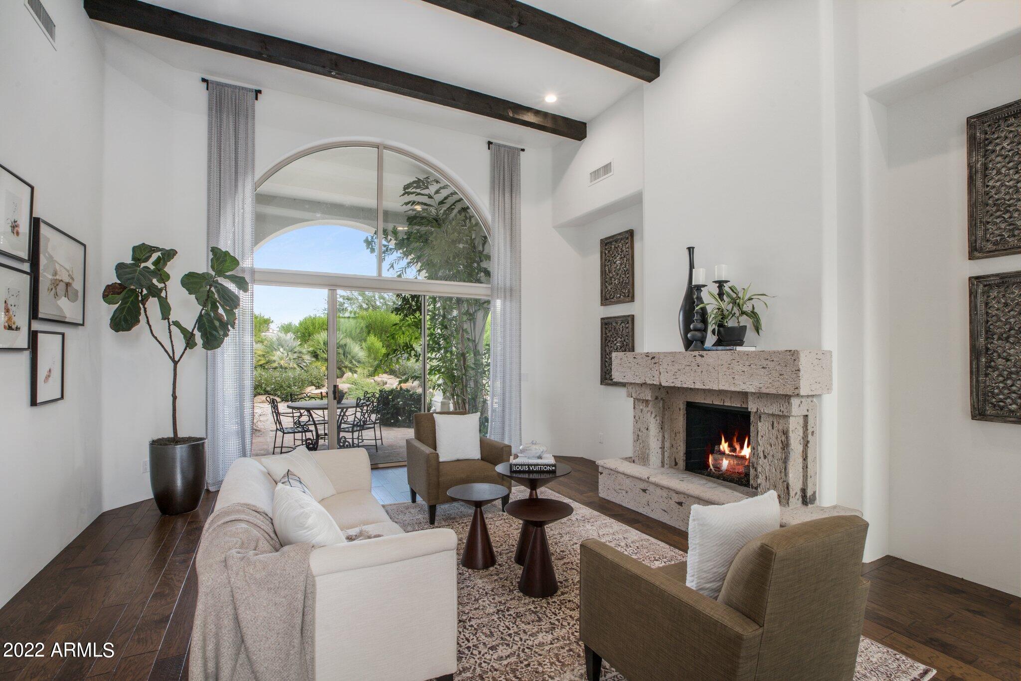 A sophisticated gem in Cheney Estates surrounded by lush, mature landscape in one of the few guard gated communities of Paradise Valley.  A sense of casual elegance leads you in where soaring beamed ceilings and a cozy fireplace frame picture windows overlooking the resort like backyard.  A spacious and versatile floor plan, almost every space was reimagined with a breathtaking modern aesthetic.  The state of the art kitchen with custom cabinetry, a sub zero fridge, granite countertops and walk-in pantry join the family room creating the ideal entertainment space. The primary suite is warm and dreamy with natural wood beams and a soothing color palette. The true spa-like bath has boutique cabinetry and heated Schluter porcelain floors.  Abundant natural light cascades from the mirrors that adorn the marble vanities all surrounding the tranquil soak tub and floor to ceiling glass steam shower. The executive office offers even greater flexibility as a 4th bedroom with it's own full bath and refined custom built in bookcases. Secondary bedrooms have en-suit baths and walk-in closets. Relax outdoors under the covered Ramada which sets the scene for an outdoor living room with a built in BBQ and overhead ceiling fans.   The backyard is a true sanctuary with your own putting green and immense fruit trees creating natural shade and plenty of privacy. Enjoy community tennis and pickleball or visit any of your favorite golf courses, resorts, restaurants and boutique shops close by.