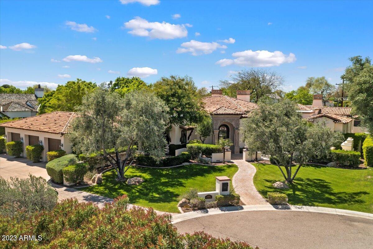 Built on a coveted ARCADIA cul-de-sac lot with convenient location to the best schools and Old Town, this home was expertly crafted in 2009 by Santorini Homes, an award-winning luxury home builder in the Valley, as the Builder's personal residence. This up-to-date masterpiece is a testament to custom craftsmanship and attention to detail. Completed with alder wood finishes, and Cantera stone details, the home exudes elegance and luxury. Featuring 5 bedrooms, 5 bathrooms, 2 half baths, and an oversized 3 car garage, this striking 6,000 sq ft home sits on a sprawling 23,252 sq ft private lot. The Chef's Kitchen with 14 ft coffered ceiling
and expansive center island has it all, 
 including a temperature-controlled Wine Room. The Master Bedroom features an attached flex room and the spa-lik bathroom featuring a soaking tub, large shower area, dual vanities, dual water closets and dual walk-in closets. The fully
finished basement with ample natural light offers the ideal space for entertainment. A Theater, Billiard Room, Gym, Powder Room, and exclusive access to the backyard are sure to create much enjoyment. This beautifully landscaped home epitomizes the appeal of quintessential luxury living with its stunning backyard boasting a sparkling lap pool and large spa with impressive water features making it ideal for family and friends. The 3 indoor Cantera stone gas fireplaces will create an ambiance of cozy warmth in colder months and the outdoor gas fireplace provides a centerpiece for garden-like gatherings and restful moments. The Savant automation system and home smart features guarantee that every comfort will be at your fingertips inside and out. Experience unparalleled style and gracious charm at its finest in this meticulously designed Arizona retreat. SEE HOME'S MOTION VIDEO!