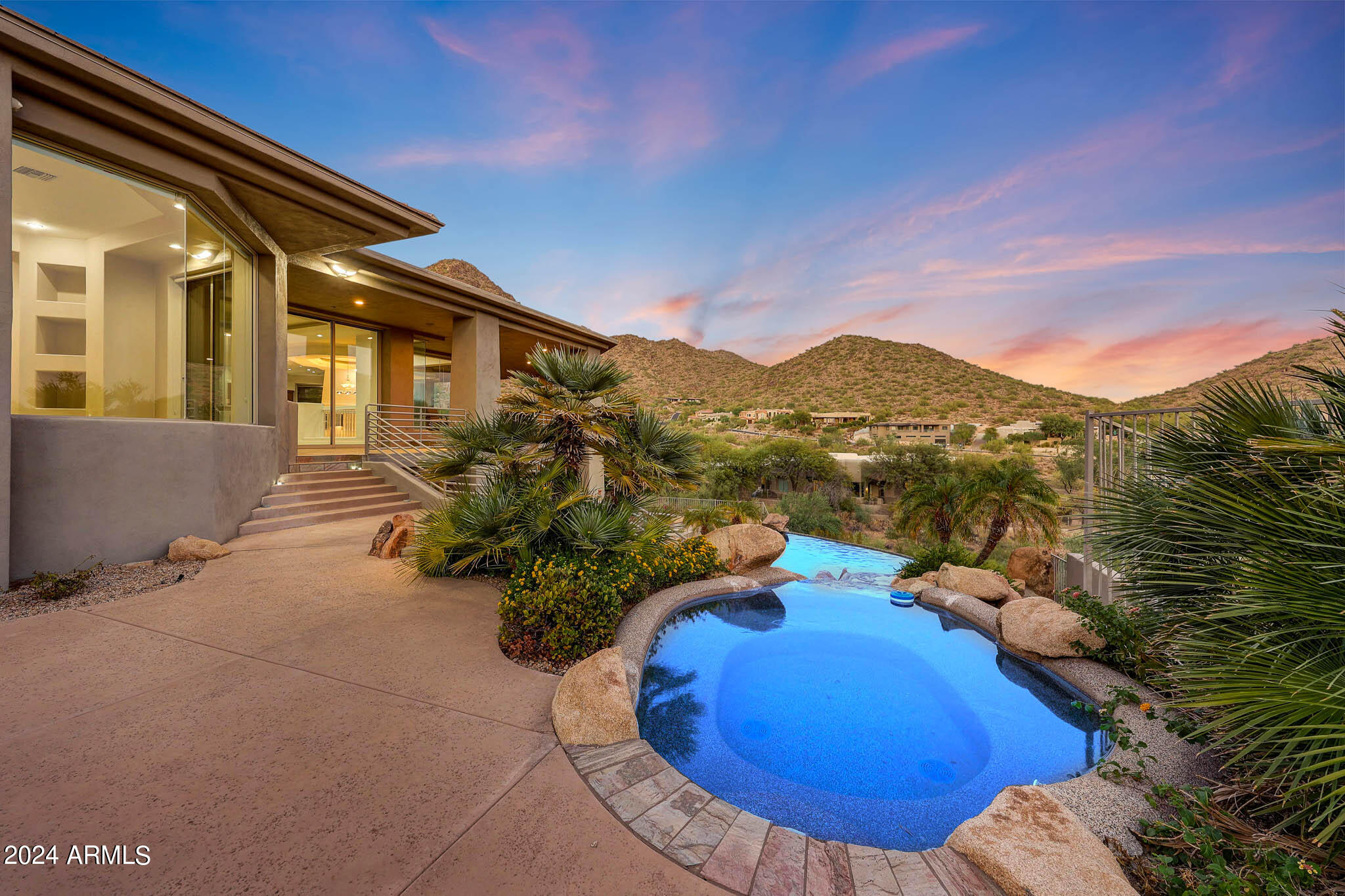 Discover the perfect blend of luxury, seclusion, and breathtaking beauty in this spectacular custom-built home, nestled within the prestigious gated community of The Canyons at Scottsdale Mountain. Forever City & Mountain Views!  Positioned securely behind two gates, including a manned entry, this contemporary masterpiece offers unparalleled privacy and exclusivity. Perched on the hillside, the home is designed to maximize its stunning views of the surrounding mountains and the sparkling city lights, creating a truly enchanting setting both day and night.
Located just moments from top-ranked schools like Basis and Desert Mountain, the renowned Mayo Clinic, and the vibrant shopping and dining at Kierland, this home delivers the convenience of city living without sacrificing tranquility. The sweeping hillside and city light views are a constant reminder of the extraordinary location, making every moment feel like a retreat.

The expansive layout is ideal for both relaxation and entertaining, featuring two luxurious primary suites, a state-of-the-art theater room, and a versatile bonus/exercise room. Outdoor living is equally impressive, with a stunning negative edge diving pool, a luxurious spa, and a firepit perfectly positioned to let you soak in the serene hillside surroundings and twinkling city lights. 

Recent upgrades, including sleek epoxy flooring in the garage and elegant engineered wood flooring on the upper level, elevate the home's modern appeal. Functionality is also prioritized, with dual laundry roomsone upstairs and one downstairsadding convenience to everyday living. 

Set within the prestigious gated community of The Canyons at Scottsdale Mountain, this extraordinary home offers the ultimate in luxury and security, surrounded by breathtaking hillside and city light views. Experience a lifestyle beyond compare in this exceptional property, where elegance meets natural beauty.