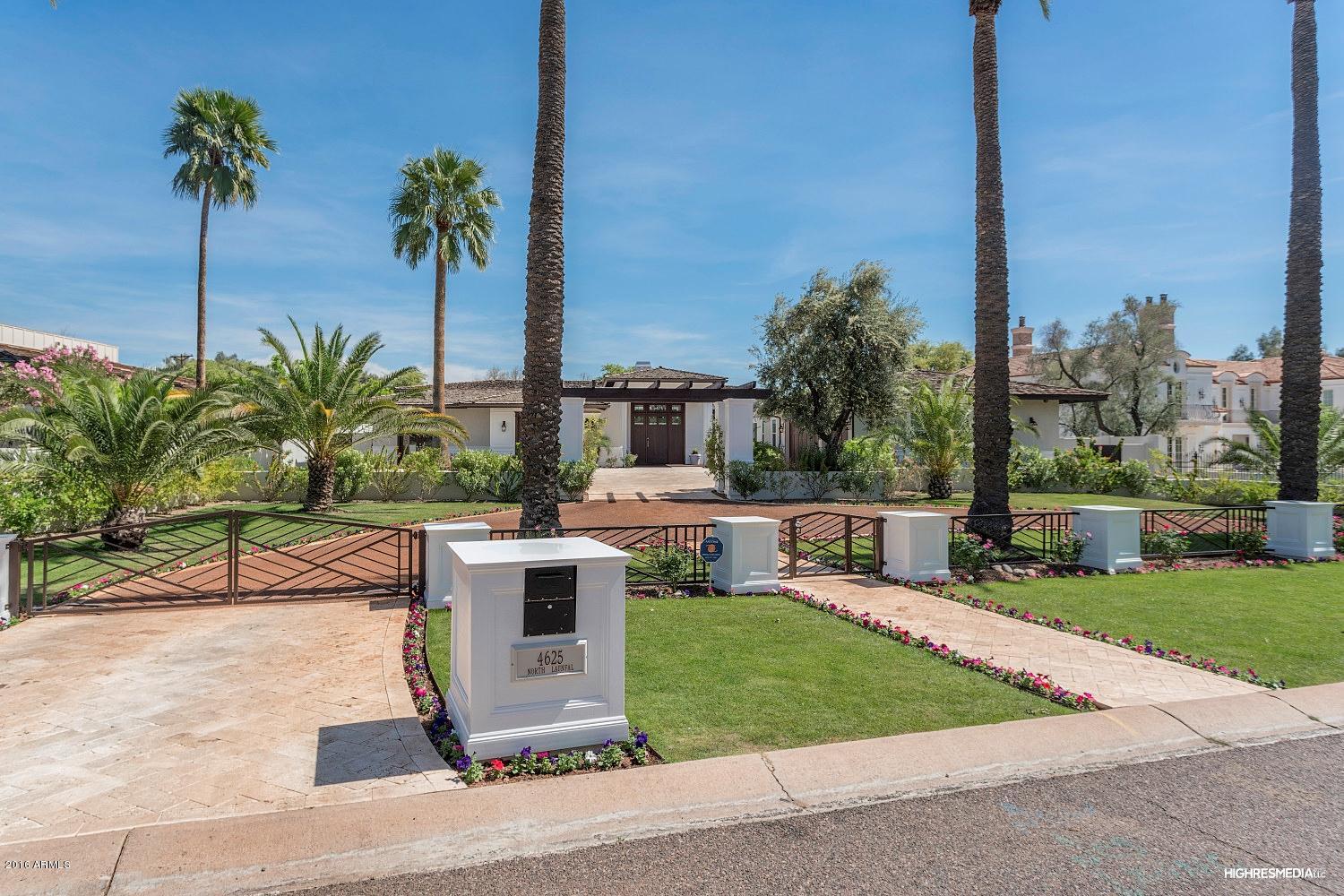 Elegant gated Arcadia estate with gorgeous Camelback Mtn VIEWS that permeate thru your entire great room, master, AND backyard.  This 6 beds/7 bath PLUS flex room features exotic handscraped hard wood floors, up to 15 ft coffered exotic wood ceilings, extensive handcrafted wood work & wainscoting.  Chef's kitchen features top of the line appliances & opens to great room & wet bar w/ hand carved imported exotic wood slab, & climatized wine cellar, perfect for entertaining.  Huge glass pocket door systems open to sweeping patio w/ beach entrance pool w/ lap lane, SPLASH PAD, spa, BBQ area, & pool bath.  Luxurious master retreat w/ indoor AND outdoor shower & beautiful tub.  TWO hidden rooms to hide valuables.  Private guest quarters w/ access thru front of home, can double as 2nd master.