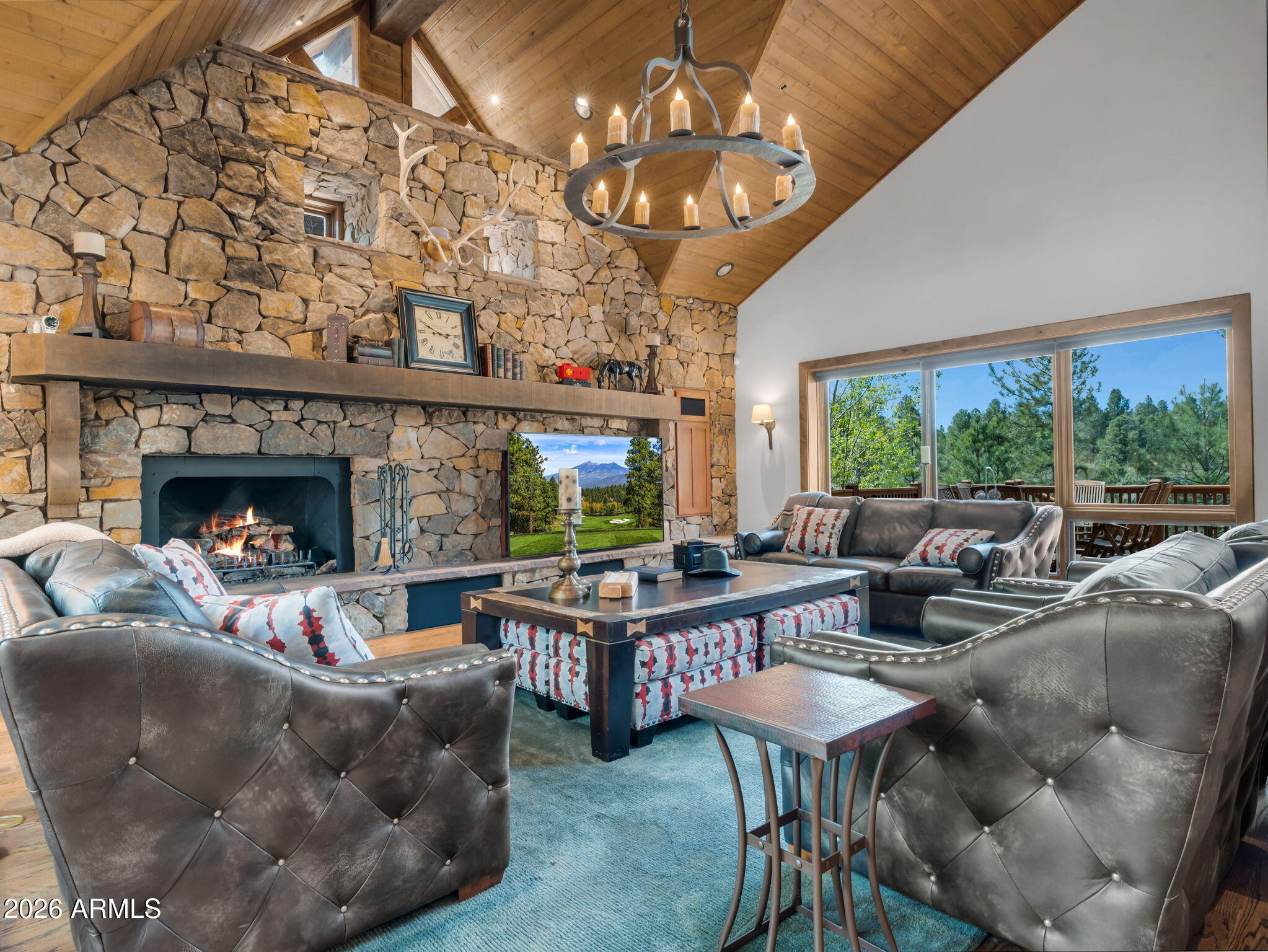 Experience refined mountain living in this stunning custom residence tucked within the prestigious Pine Canyon community. Set on a private half-acre homesite, this 4,097 square foot retreat offers 3 bedrooms, 3.5 bathrooms, and a spacious loft, all thoughtfully designed to capture the warmth and character of a luxury mountain lodge. Surrounded by towering Ponderosa Pines, the home showcases unparalleled panoramic views of the 12th tee box, rolling fairway, picturesque stone bridge, tranquil lake, and distant mountain backdrop. Inside, rich wood flooring flows throughout the home, complemented by dramatic exposed wood beams, soaring vaulted tongue-and-groove ceilings, and an extraordinary floor-to-ceiling stone fireplace that anchors the main living space.
The beautifully remodeled kitchen, completed in 2022, blends timeless craftsmanship with modern functionality, creating the perfect space for entertaining and everyday living. The primary suite is a private sanctuary on the main level, featuring its own fireplace, expansive walk-in closet, and a spa-inspired bath with dual vanities, dedicated makeup area, standalone soaking tub, and separate walk-in shower.
Outdoor living is equally exceptional with an expansive redwood deck designed for year-round enjoyment. Relax in the hot tub while taking in the serene golf course and mountain views, or entertain with the outdoor fireplace, built-in heaters, and television lounge area.
Additional recent upgrades include a new roof and new water heaters, both completed in 2026, offering peace of mind for years to come. Combining privacy, architectural character, and breathtaking surroundings, this extraordinary Pine Canyon retreat delivers an unmatched mountain lifestyle experience.