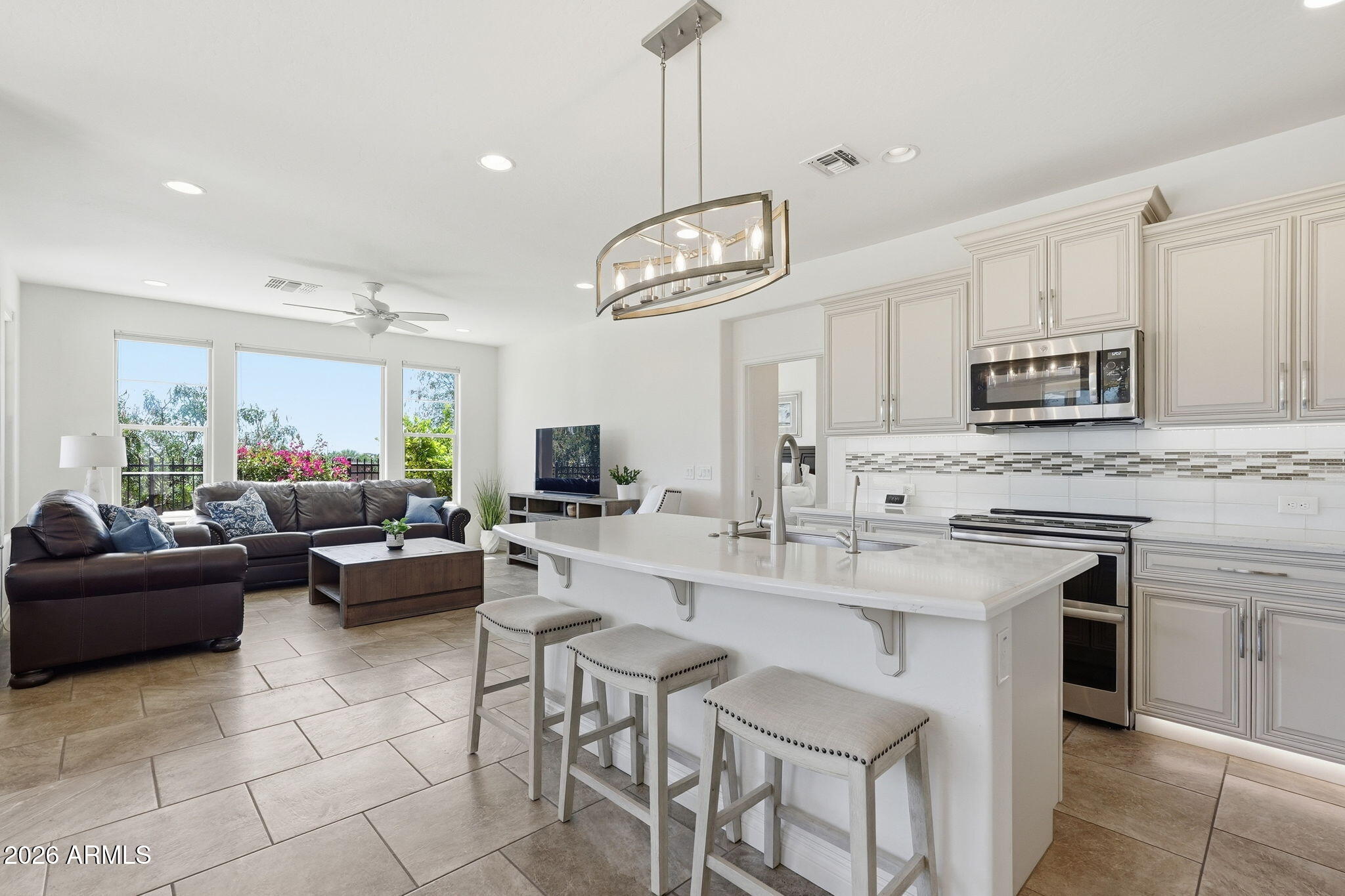 Welcome to Encanterra, where resort-style living meets comfort and convenience! This beautifully maintained townhome sits on a premium homesite with no neighbors behind, offering added privacy and serene views. The split floor plan is ideal for full-time living or a lock-and-leave lifestyle. Inside, enjoy tile flooring throughout, luxury quartz countertops, stainless steel appliances, and double ovens. Both bathrooms feature fully tiled walk-in showers, and quartz countertops. Front and back landscaping are included for easy living. Just steps from golf, pickleball, pools, dining, and more--experience the best of Encanterra!