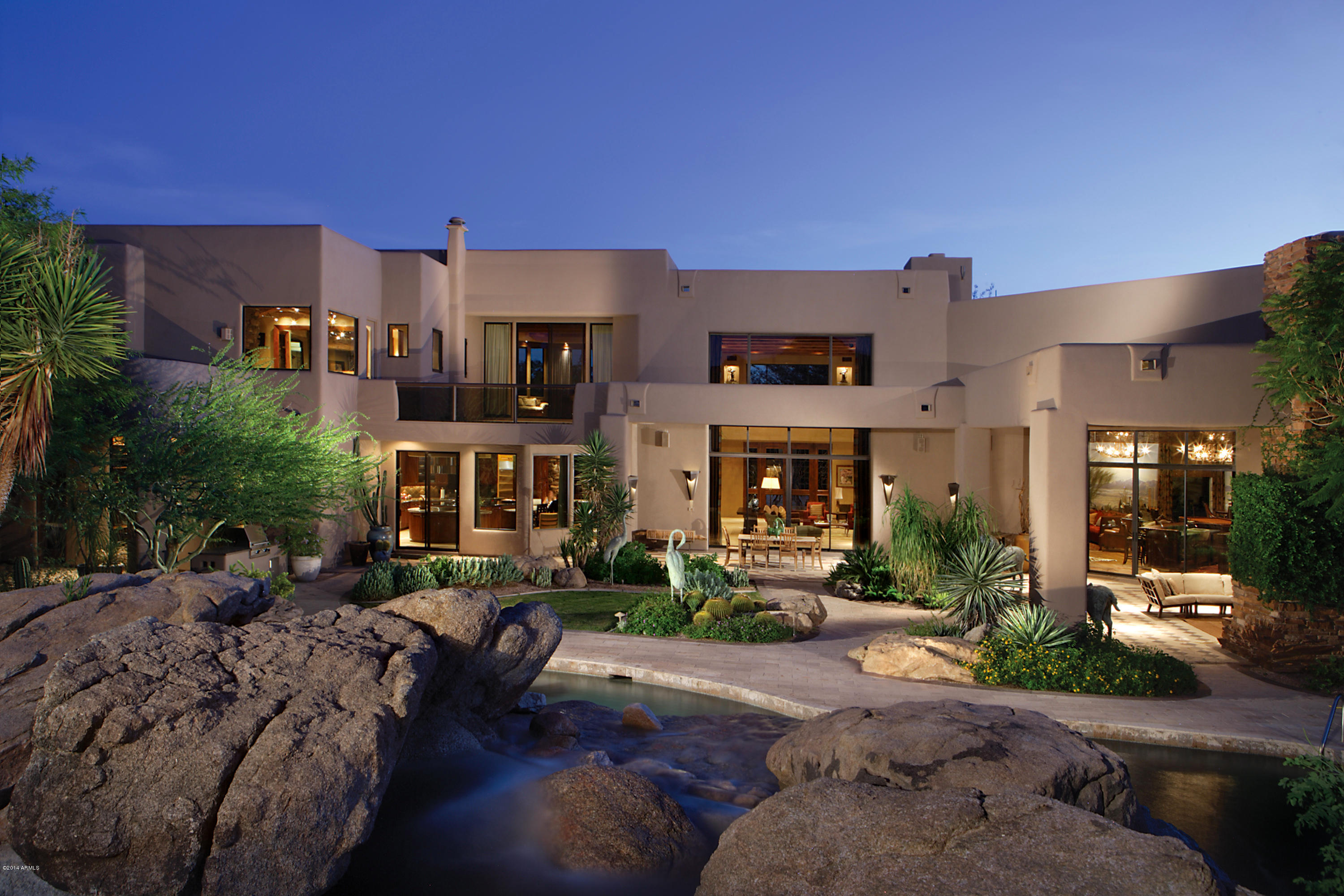 This is the personal home of a custom home builder and a designer. Their professional collaboration, sourcing of fine materials and selection of talented craftsmen have created a timeless four acre estate. Designed for those that have a passion for cooking & entertaining, whether hosting large social circles or family & friends. The kitchen accommodates multiple cooks with free form counters & four custom pantries.  The dining room's wall of glass opens to alfresco dining in the alluring front courtyard. The great room boasts the grandeur of 20 foot high ceilings and walls of glass open to create a sophisticated fusion with the luxe pool and grounds. This home was designed around the views of the iconic Pinnacle Peak, and the beauty of its surrounding take center stage. A 3,000sf guesthouse perfectly accommodates staff or weekend guests.