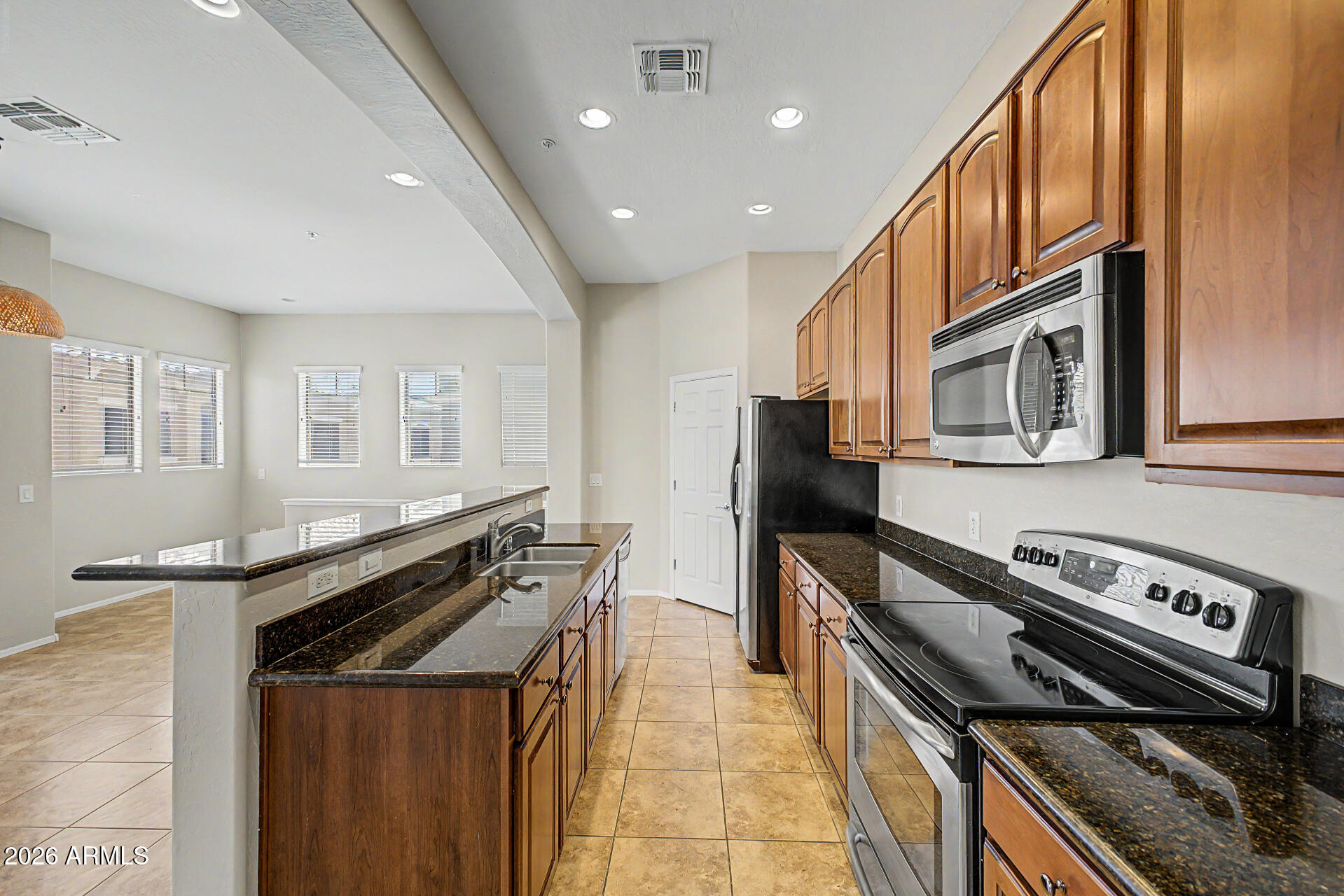 Beautiful 2-bedroom, 2-bath condo located in the heart of Surprise, close to shopping, dining, and entertainment. This gated community offers resort-style amenities including a pool, spa, fitness center, playground, and walking paths. The home features a 1-car garage with direct access to the unit, as well as an additional assigned parking space conveniently located near the unit. Inside, you'll find tile flooring throughout the main living areas and a neutral color palette. The kitchen is equipped with granite countertops, stainless steel appliances, recessed lighting, and a pantry for extra storage. Both bedrooms offer comfortable carpet flooring, while the spacious primary suite includes an ensuite bath with dual vanities and a walk-in shower. Convenient in-unit laundry room. Enjoy low-maintenance living with great community amenities in a prime location.