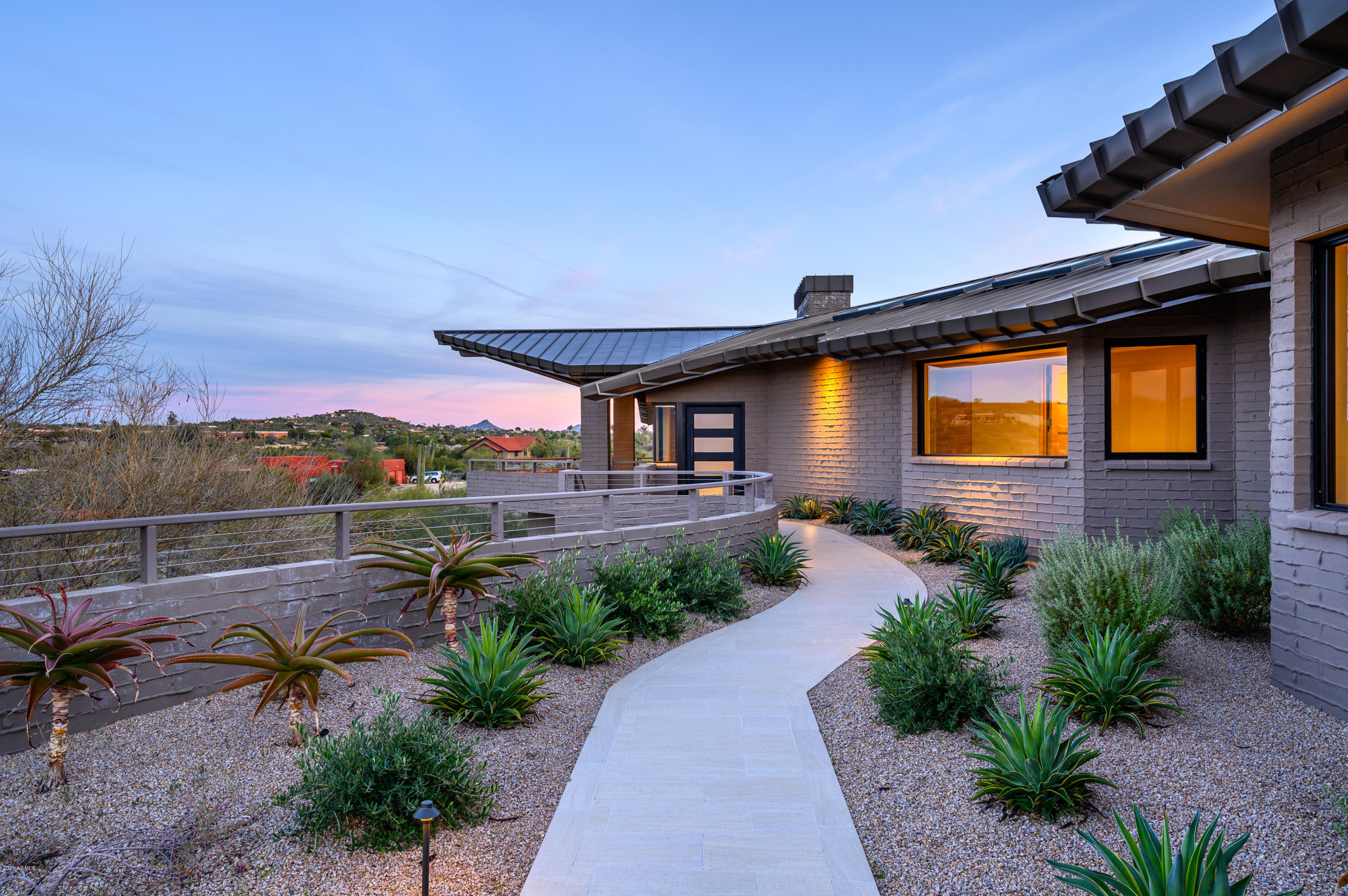 Timeless Desert Contemporary residence on the northeast slope of Black Mountain within the Gated Community of Nighthawk.  Consummate low maintenance design plus highest level of workmanship that will last a century. Renowned architect Gerry Jones has fashioned a lasting gem here with his 68 years of experience in architecture and construction, as well as 17 years teaching extreme terrain mountain design at Frank Lloyd Wright's Taliesin West. Nighthawk is a quiet gated community containing only eight multi-acre lots. This distinctive 3.15 -acre site is the  largest site within Nighthawk, includes lush Sonoran vegetation, huge granite boulders, desert wildlife and breathtaking views over Carefree, AZ. Please watch home's MOTION VIDEO, then Open the Document File to learn more about this home See Continental mountains. Like all of Jones' custom residences this home is designed in harmony with nature, resting gently into the curves and rocks of the land. The beauty of this 5,270 square foot 5 Bedroom, 5.5 Bath masterpiece includes long slender lines, Jones' trademark intricate roof, deep overhangs for shade, and extensive windows embracing views of Black Mountain and its surrounding valley. Fourteen skylights sprinkled throughout the residence soften the midday light. 
In addition to its beauty, this home is built far beyond legal code, using construction standards that will allow it to remain structurally sound for 125  150 years. With masonry construction, a standing seam roof, and natural landscaping, it requires very little maintenance. Green building materials and energy saving features keep operating costs to a minimum. Interior finishes are low-maintenance yet high in quality. Enjoy the Peace and Quiet of your desert surroundings in a home that does not require constant upkeep. All in all, this jewel is a beautiful low-maintenance home built to last for generations.