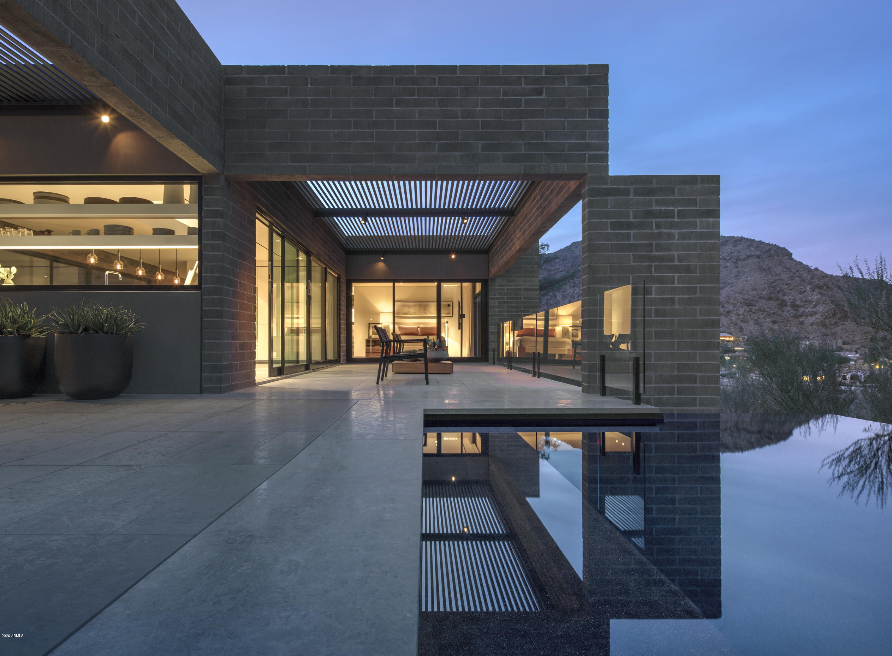 This stunning hillside contemporary was designed by acclaimed architect Ned Sawyer & is the personal residence of the award-winning designer David Michael Miller. A complete remodel was finished in 2016. Positioned on the Northeast slope of Mummy Mountain, the dramatic views of the McDowell Mountains & Pinnacle Peak are panoramic. Constructed of Founders block with a horizontal profile, the home is nestled quietly into the natural desert surroundings. The interior finishes include European Oak hardwood & Portuguese Limestone flooring, custom rift-cut Walnut & Oak millwork, Allison Berger lighting, Fleetwood doors & windows, motorized shades, Savant/Lutron house management system, Vola & Duravit plumbing fixtures and a Bulthaup kitchen.  A very unique opportunity for a discerning buyer.