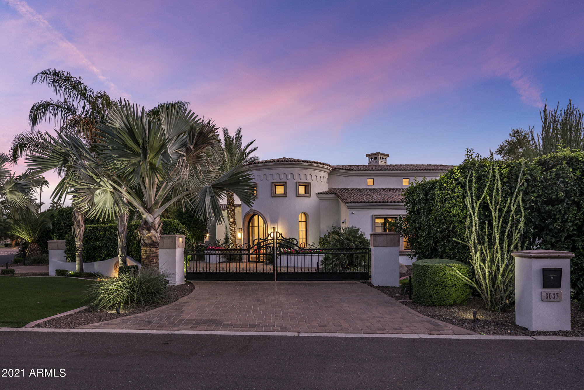 Privately gated soaring ceiling modern Santa Barbara style home. Large indoor outdoor slider windows pour into the resort like backyard with views of Mummy mountain and the perfect mix of indoor/outdoor living. Restoration hardware fixtures, Calcutta marble, wide plank white oak floor with touches laid in herringbone, back lit onyx bar, this home has been done to the nine's! Split floorplan featuring master and office on one wing, three en-suite bedrooms down the second and detached guest house with it's own complete kitchen and living. Additional full movie theatre, large eat in kitchen, luxurious master bath and 5 car separately gated garages. CCC school district, best in Paradise Valley, close to shops, restaurants and golf.