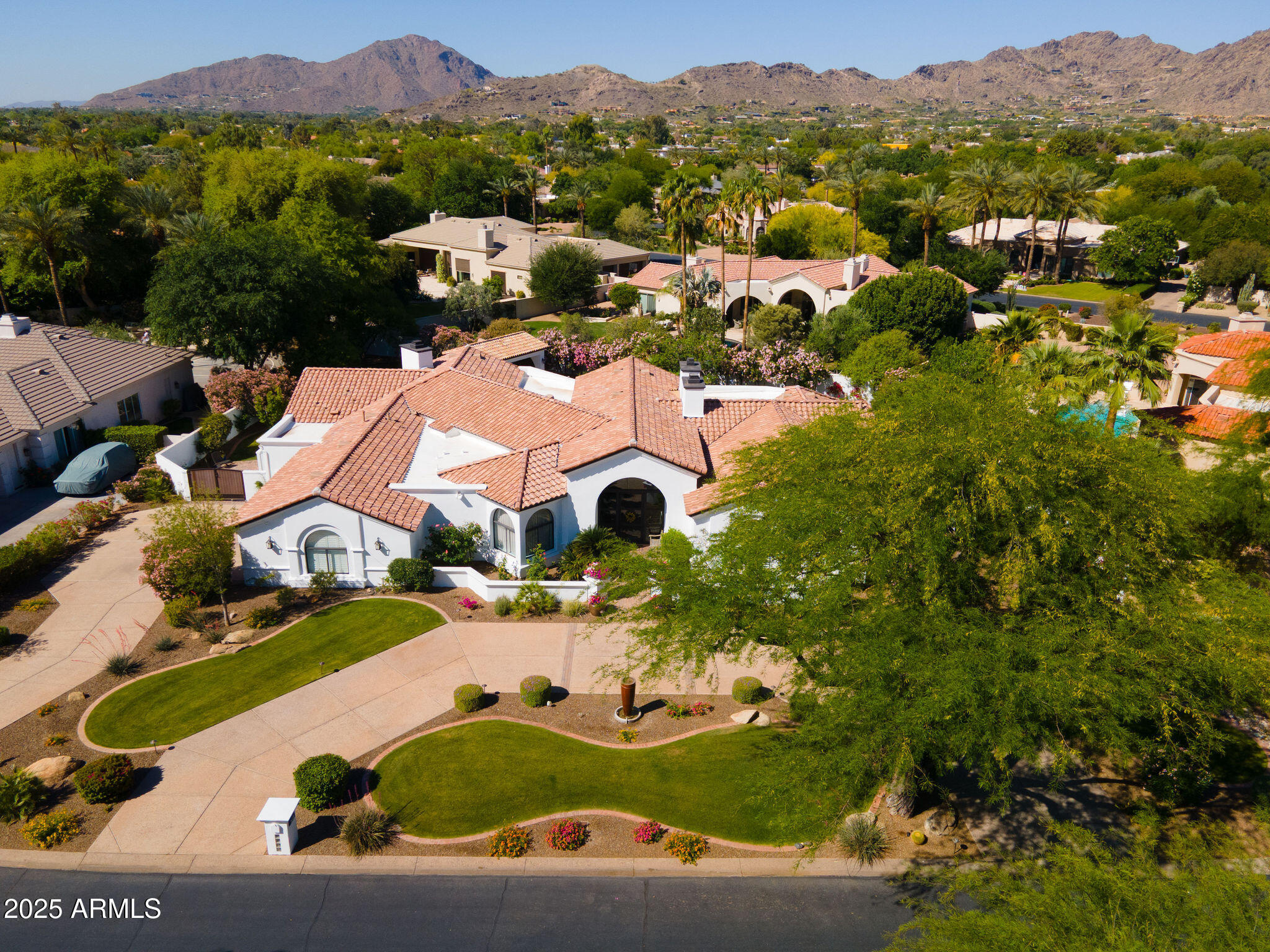 Exquisitely reimagined between 2019-2024 with over $1,000,000 in high-end finishes, this turnkey residence offers timeless elegance and modern functionality. Nestled in coveted guard-gated Cheney Estates, this home features White Oak hardwood flooring, custom millwork, designer wall coverings, interior & exterior motorized shades, and bi-fold doors opening to a lush outdoor retreat with a poolside ramada and grill. The chef's kitchen boasts a large island with integrated seating, Wolf appliances including a built-in coffee station and ice maker, Sub-Zero refrigeration, spacious hidden pantry, and two dishwashers. The split primary suite impresses with a marble fireplace, soaking tub, rain shower, expansive custom closets, and a Wolf beverage station. All guest bedrooms are ensuite, and a 4th bedroom with Murphy-bed and built in desks. A main den/office is located off the entry with custom millwork and bookshelves.  Recent exterior upgrades include a new tile roof, paint, RV gate, irrigation, landscape lighting, and newly epoxied garage floors. Control4 automation, surround sound, central vac, and extensive mechanical upgrades make this home move-in ready. Enjoy tennis, pickleball, and the security of a gated community in one of Paradise Valley's most coveted enclaves, limited to just 72 residences. All within walking distance to more than 30 exceptional restaurants and boutiques, with convenient freeway access nearby.