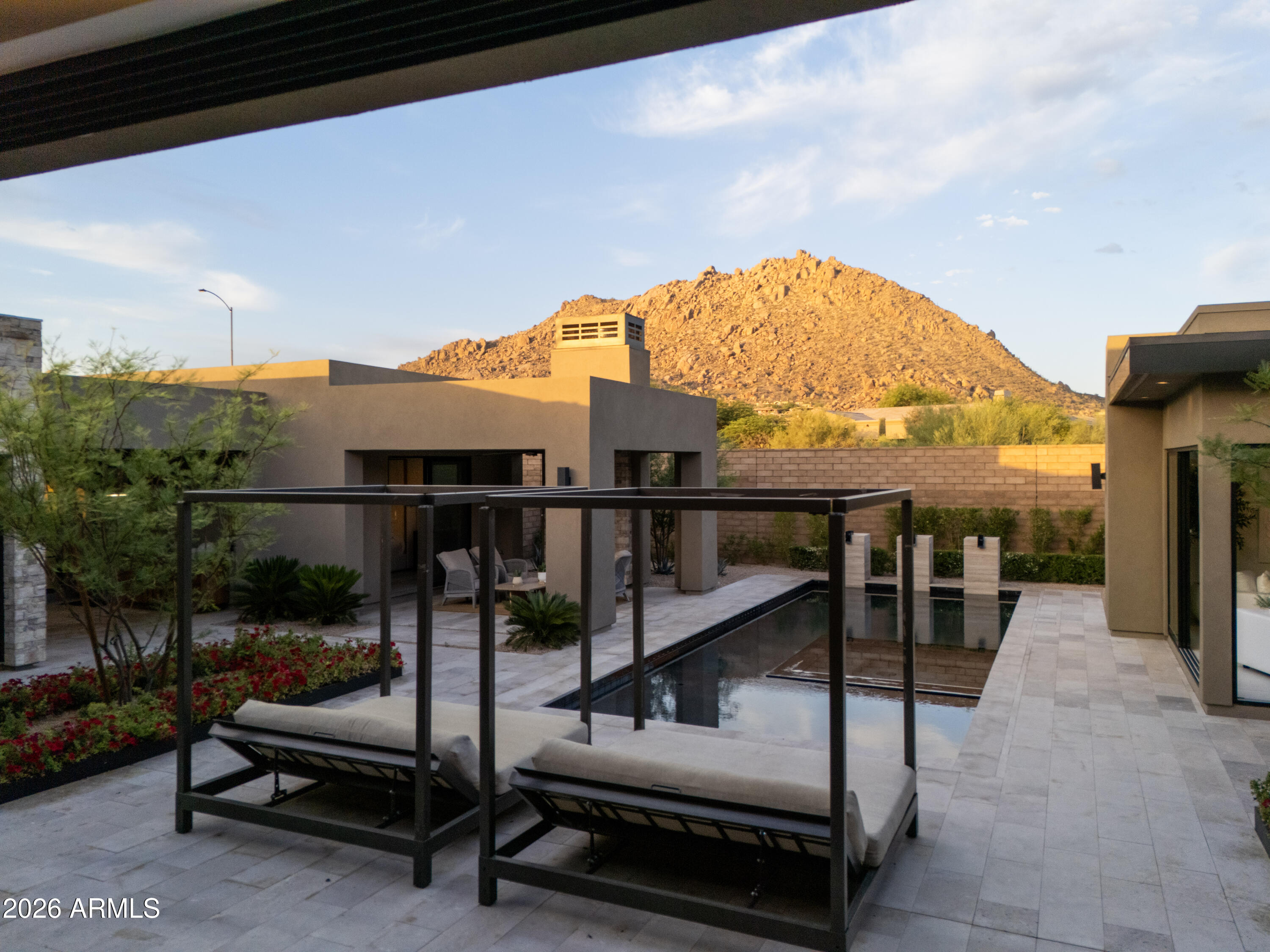 A Striking Expression of Contemporary Luxury in North Scottsdale.

Experience elevated desert living in this just-completed, single-level showpiece by Camelot Homes, showcasing the award-winning Cavallo floor plan. Perfectly positioned to capture panoramic views of Troon and the majestic McDowell Mountains, this residence blends clean architectural lines with warm, organic textures--defining today's modern luxury.

Thoughtfully designed for seamless indoor-outdoor living, expansive glass walls flood the interiors with natural light and frame the surrounding desert landscape. The open-concept great room flows effortlessly into a state-of-the-art chef's kitchen, where contemporary custom cabinetry, oversized statement tile, and dramatic slab countertops create a bold yet sophisticated aesthetic. A stunning temperature-controlled wine wall serves as both focal point and functional art, while advanced electrical upgrades and tailored window treatments reflect a commitment to comfort, innovation, and refined style.

The split floor plan offers three spacious ensuite bedrooms, a private casita for guests, a dedicated office, and a versatile bonus room with a built-in bar--ideal for entertaining or relaxing in style. A 4-car garage provides ample space for vehicles, storage, and lifestyle flexibility.

Outdoors, an award-winning desert retreat designed by Creative Environments elevates the experience even further. The custom pool, curated hardscape, and lush desert landscaping create a resort-inspired setting that is both serene and spectacular.

Newly completed and move-in ready, this contemporary masterpiece delivers timeless design, exceptional craftsmanship, and an unparalleled lifestyle in one of Scottsdale's most coveted enclaves.