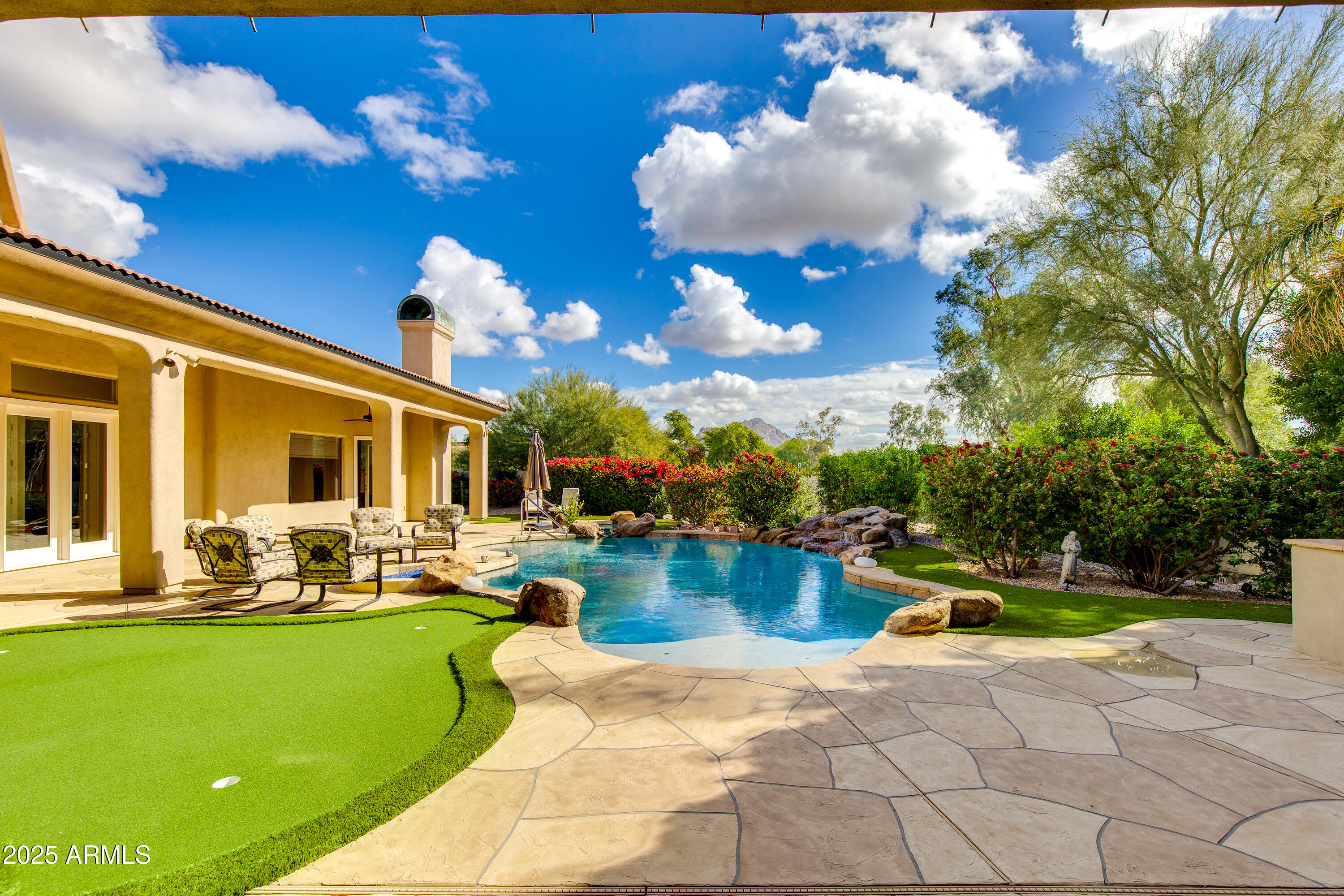 Designed to capture views of Camelback Mountain from every main living space, this exceptional North/South-oriented Paradise Valley estate exemplifies the pinnacle of desert luxury. Minutes from the Valley's finest dining, shopping, and amenities, this residence combines architectural sophistication with resort-style living.  The floorplan was masterfully designed to maximize the sweeping views, featuring spacious room proportions, expansive windows, soaring ceilings, and high-end finishes that define the finest in architectural design. 
The grand primary suite is a private sanctuary with a sitting area and Cantera fireplace overlooking the sparkling pool and Praying Monk. The home also includes three oversized guest bedrooms all with ensuite bathrooms and large walk-in closets.  A dedicated office also provides space near the primary bedroom for a quiet workspace.  The gourmet kitchen features a gas cooktop, premium appliances, wet bar, wine storage, and a thoughtfully designed butler's pantry, perfect for both entertaining and everyday living.
Outdoors, enjoy resort-style amenities with a pool and spa, putting green, fire pit, built in BBQ, low-maintenance artificial turf, and lush landscaping, all set against the stunning backdrop of Camelback Mountain. Additional highlights include a 4-car garage with abundant storage, smart home upgrades and  timeless architectural lines that maximize privacy while elevating the mountain-view experience.