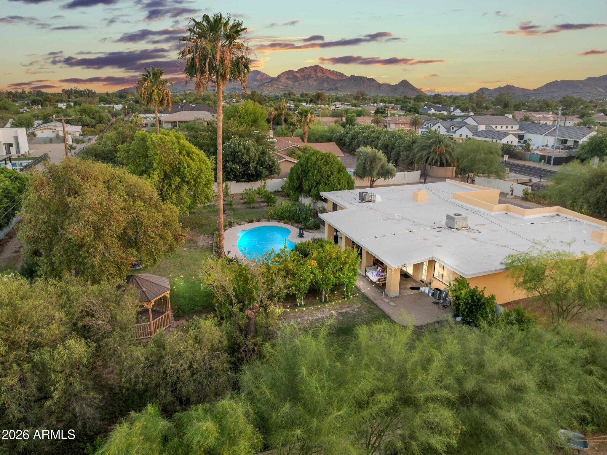 Excellent opportunity to own a wonderful home on an acre+ lot in Paradise Valley! With over $400K in recent upgrades and improvements, it is move-in ready as-is and by far the most affordable home on an acre in Paradise Valley. Or at this price, add on or start over and create your dream property. New builds on similar size lots in the immediate area are listed at $5.7M and up! The current home offers a 4 bedroom split floor plan with 2.5 bathrooms plus a 2 car garage. Mature trees and lush foliage envelope the backyard providing privacy, shade and lots of greenery to enjoy. Relax on the spacious covered patio, under the gazebo, or take a swim in the large sparkling play pool. Enjoy fruit from a variety of trees ranging from orange, apple, guava, lemon, peach, fig, persimmon, and ... more! Enter the property through a motorized gate (controlled by clicker or phone app). Beautiful new paver driveway with turnaround circle plus extra parking to the side of the garage. Three RV gates and plenty of room to park an RV ... or do/build/add whatever suits your needs on the huge portion of the lot that has not even been developed yet. NO HOA. Located in the Scottsdale school district and in boundaries for 'the 3 C's' - Cherokee, Cocopah, and Chaparral ... the most desired schools in the district! Convenient access to both the 51 and the 101 freeways. Awesome location just minutes to great restaurants, shopping, entertainment, recreation, hiking, etc! Approximately only 4 miles to Kierland Commons, Scottsdale Quarter and the newly redeveloped Paradise Valley Mall area! Under 7 miles to Scottsdale Fashion Square Mall and Old Town Scottsdale. A 9 minute drive to Scottsdale Airpark and only 20 minutes to Phoenix Sky Harbor. The $400K in recent upgrades and improvements include: opening the floor plan and leveling the sunken living room, all new travertine floors throughout the home and on the patio, new kitchen and all 2.5 bathrooms fully remodeled, lots of recessed lighting added plus all new smart home light switches installed, fresh interior and exterior paint including the block wall, 350 linear feet of new block wall, pavers and new gate at entry, water features including the front entry pondless waterfall & a tiered water fountain in back, gazebo installed in backyard, new grass and additional landscape including 117 new trees! New septic installed when they bought the home in 2024. Tour today and you will want to call this house home!