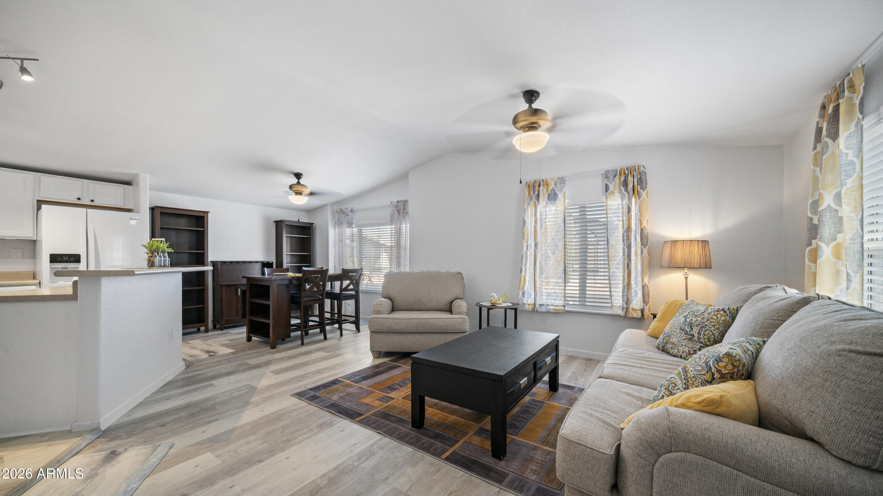 Welcome to this beautifully updated, move in ready home nestled in the desirable 55+ community of Saguaro Canyon! Tucked away from the main road, this community offers a serene and relaxing atmosphere while remaining conveniently located. From the moment you arrive, you'll appreciate the fresh exterior paint, giving the home a modern, refreshed appearance, along with the convenience of side by side parking and a ground set design with no steps. Inside, updated interior paint and stylish wood look flooring create a warm and inviting atmosphere. The spacious living room comes fully furnished with updated, modern furnishings, making it the perfect place to relax or entertain. The open concept kitchen features bright white cabinetry, matching white appliances, and a skylight that fills the space with natural light. This furnished two bedroom, two bathroom home makes moving effortless, with no need to haul large furniture. The spacious primary suite features a generous walk in closet and an updated ensuite bathroom with a beautifully renovated walk in shower for added comfort and accessibility. Outside, you'll find a spacious shed/workshop and a private backyard retreat complete with a covered patio, gazebo, and fenced yard that's easy to maintain and ideal for pets. Major updates, including a newer roof and updated air conditioning unit, provide added peace of mind for years to come. Combining modern updates, thoughtful features, and exceptional outdoor living, this home is truly move in ready and waiting for you to enjoy!