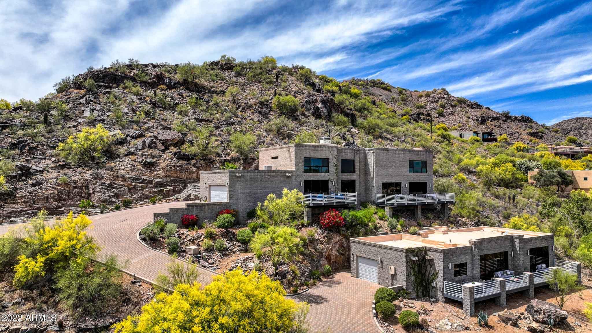 VIEWS, SUNSET, DRINKS & HORS D'OEUVRES. Views so Majestic you will have to see to believe, arguably the best Paradise Valley has to offer. This Home & Guest House Perched atop Mummy Mountain are simply One of a Kind! This private Cul-de-sac 4661 sqft Hillside home has a 1436 sqft 1br/1ba, 1car Guest House for a total of 6097 sqft. This is an extraordinarily rare property that is sure to leave you in Awe. Both homes have an unparalleled view from every window & balcony, whether it is the Carved Hillside Rock Waterfall or watching the lights dance on Talking Stick Resort at night. Overlooking the New 2 Billion Dollar Ritz Carlton Resort which is set to open in Fall is a bike ride away & only minutes to Old Town Scottsdale is a location that is second to none