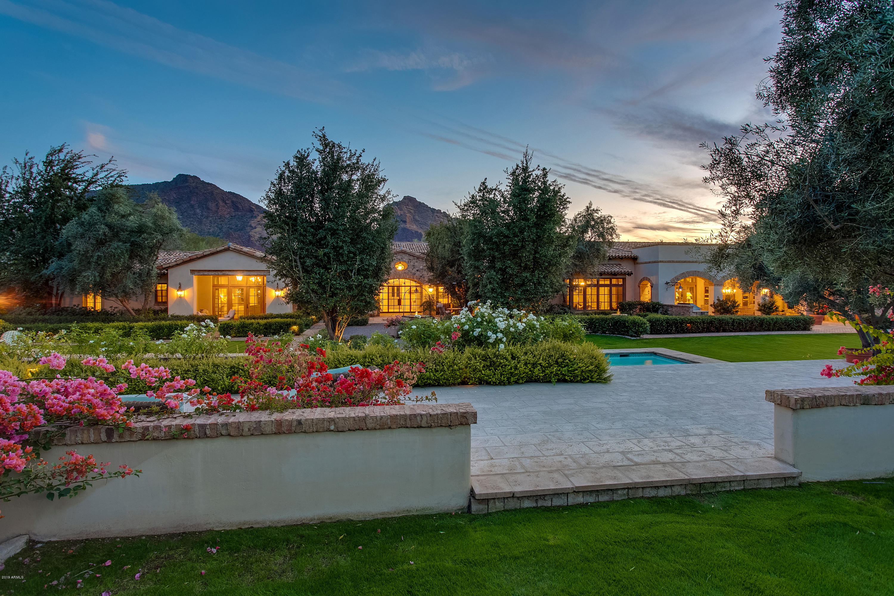 Rarely does a home with this level of exceptional detail and quality come to the market.  This 2.14 acre Paradise Valley estate is situated on the Paradise Valley Country Club golf course with unobstructed views of Mummy Mountain.  Built with refined taste by the current owners in 2009, this gorgeous French style farmhouse is both relaxed and sophisticated.  From the moment you drive through the gated entry and enter the front courtyard, you will recognize the timeless appeal of this stunning home. Set against an elegant selection of antique building materials and finishes from throughout Europe, this home unfolds before you as you enter through the 19th Century antique French oak front door.  Absolutely no detail was overlooked to create the authenticity of a European estate home; plaster walls, 1" solid wide plank French oak flooring, reclaimed French oak timber beams and trusses, Hope's solid steel handcrafted windows & doors, French & Italian antique light fixtures and iron work are throughout this home. At the heart of this home is an amazing kitchen with custom European style quarter sawn white oak cabinetry, Belgian bluestone countertops, French antique parefeuille terracotta tile flooring, and an antique reclaimed brick fireplace opening to a beautiful Great Room.  In the expansive Great Room is an 18th century antique French limestone fireplace surround and a wall of Architectural Traditions Incense Cedar wood custom dual pane doors that open to a large, covered reclaimed antique Spanish brick patio consisting of an outdoor bar/kitchen and large dining area.  Room after room opens to expansive covered patios, courtyards and walkways with multiple outdoor fireplaces and cozy seating areas to take advantage of the beautiful setting and the perfect Arizona climate. The estate boasts six fireplaces, a four car garage, wine cellar,  a 1200+ square foot private entry guesthouse, a European style pool and cabana, a roof deck w/unobstructed views of both Camelback and Mummy Mountain, a sliding gate which opens the backyard to the Paradise Valley Country Club golf course. This lovely 11,412 square foot residence is a beautiful and warm family home as well as a tasteful, elegant estate in which no detail has been overlooked.  

Some other details to understand & appreciate when viewing this home are: 

-Paul Ferrante Lighting - Entry Foyer 
-Antique Italian Chandelier 18th Century- Hallway Foyer
-Antique Dining Room Chandelier 18th Century
-Custom Zinc Wet Bar Top- Great Room
-Louis the XIII Antique French Oak Wine Cellar Door circa 1760
-Louis the XIV Antique French Walnut Den Door 18th Century 
-French Reclaimed Hexagon Terra Cotta Tiles- Guest Bathrooms
-Early 18th Century Venetian Painted Double Scalloped Window w/Divided Lights & Shutters circa 1700- Master Bathroom
-French Antique Limestone Stone Trough Sink- Guest Bathroom 
-Antique Reclaimed Chicago Brick Lintels
-Solid Block Construction throughout with Spray Foam Insulation
-Pool Cabana with TV, Wet Bar, Bathroom/Changing Room
-Sport Court
-Private Golf Cart Path on East Side of Property
-Imported French Antique Limestone Well- Rear Courtyard Water Feature