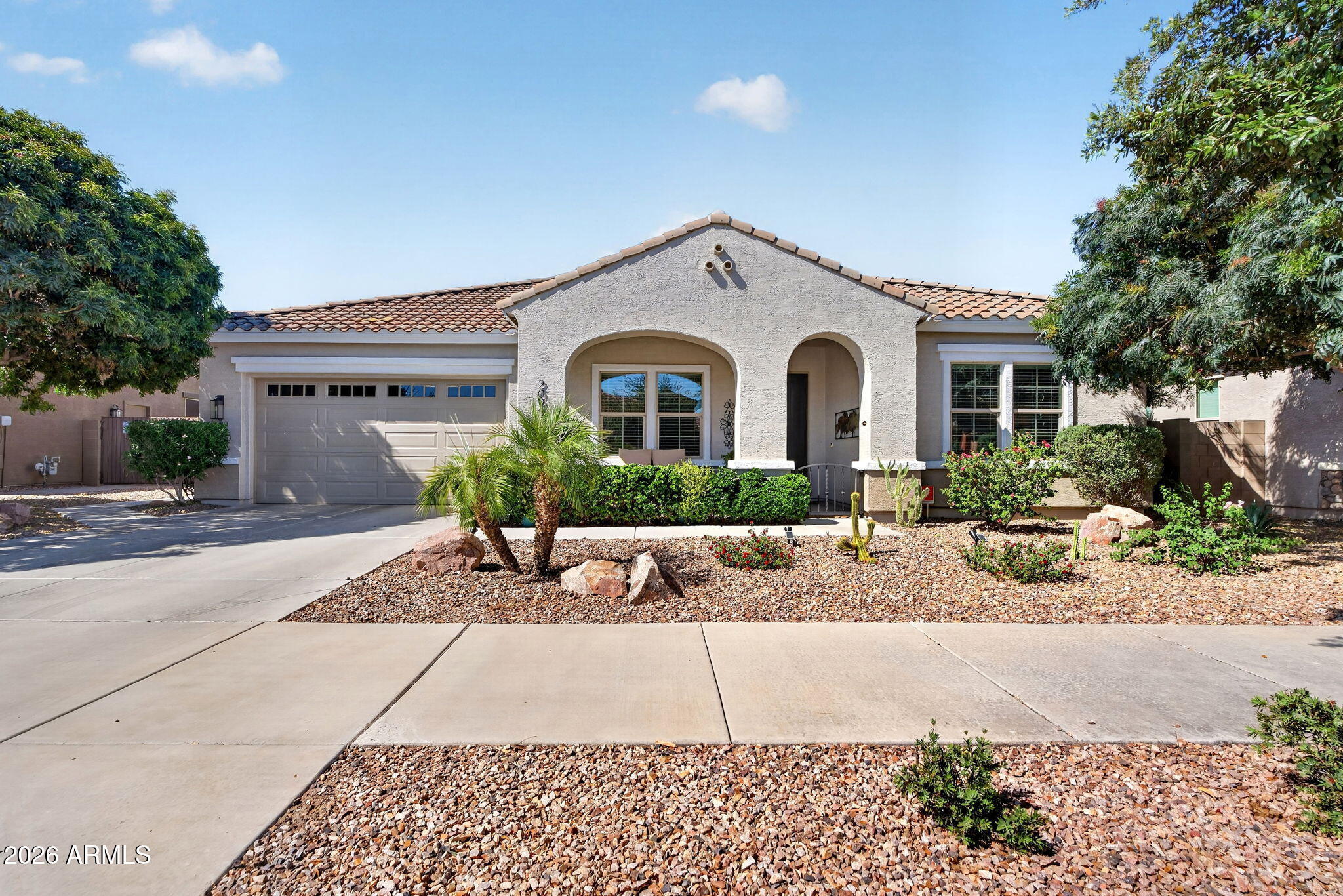 Qualified buyers may be eligible for a FREE temporary interest rate buydown on this home. Inquire for more info! Welcome to Your Private Arizona Retreat in Hastings Farms, Queen Creek! Tucked against the natural beauty of the Queen Creek Wash, this stunning single-level home is more than a residence -- it's a lifestyle. Set on a nearly quarter-acre lot in one of Queen Creek's most coveted communities, the property delivers rare wash-side privacy, sweeping open-space views, and seamless access to the miles of walking, biking, and running trails that define the outdoor Arizona experience.

Step inside and feel immediately at home. The open, single-level floor plan flows effortlessly, with 4 bedrooms, 3 full baths, a spacious office/den that easily doubles as a fifth bedroom, and a formal dining room -- all designed without a single interior step. At the heart of the home, the great room impresses with a warm gas fireplace and an included 80" wall-mounted Smart TV and complete entertainment system, creating an inviting space to gather, relax, and entertain. Two additional wall-mounted Smart TVs make this home truly move-in ready.

The gourmet kitchen is a chef's dream and a host's best asset. Anchored by a large central island and wrapped in rich granite countertops, it features stainless steel appliances, double ovens, a gas cooktop, a striking tile backsplash, and high-end soft-close cabinetry with LED accent lighting. An oversized walk-in pantry -- complete with an included stand-up freezer -- offers the kind of storage rarely found in homes at any price point.

Throughout the home, custom built-ins add both elegance and purpose, while thoughtful touches like double vanities, plantation shutters, and a programmable thermostat elevate everyday living.

The backyard is nothing short of extraordinary. Backing directly to the Queen Creek Wash with no rear neighbors, this professionally landscaped tropical oasis was designed for Arizona's signature indoor-outdoor lifestyle. A Presidential Pools saltwater pool takes center stage, complete with an in-floor cleaning system, soothing waterfall feature, and full smartphone control. 

Gather around the built-in outdoor gas fireplace, host under the covered patio or gazebo, or enjoy the low-maintenance synthetic turf and raised garden beds framed by lush, mature tropical plantings. Exterior landscape lighting illuminates the entire space beautifully after dark, and the included stainless steel natural gas Weber grill ensures you're always ready to entertain.

The extended-length, tandem 3-car garage is a standout in its own right -- featuring extra-tall ceilings, custom epoxy flooring, built-in cabinetry, and four ceiling-mounted storage units that offer exceptional organization and capacity rarely seen in residential garages.

Hastings Farms is a master-planned community that checks every box -- attractive newer homes, community trails, playgrounds, and mountain views, all within easy reach of Queen Creek's vibrant mix of shopping, dining, parks, and recreation. Queen Creek offers a rare blend of small-town warmth, modern conveniences, local restaurants, agritainment, and year-round outdoor recreation.

This is the one. A private wash-side setting. Resort-caliber outdoor living. A gourmet kitchen. A garage that rivals any workshop. And the kind of move-in-ready condition that's nearly impossible to find. Come experience it in person -- this home won't last.