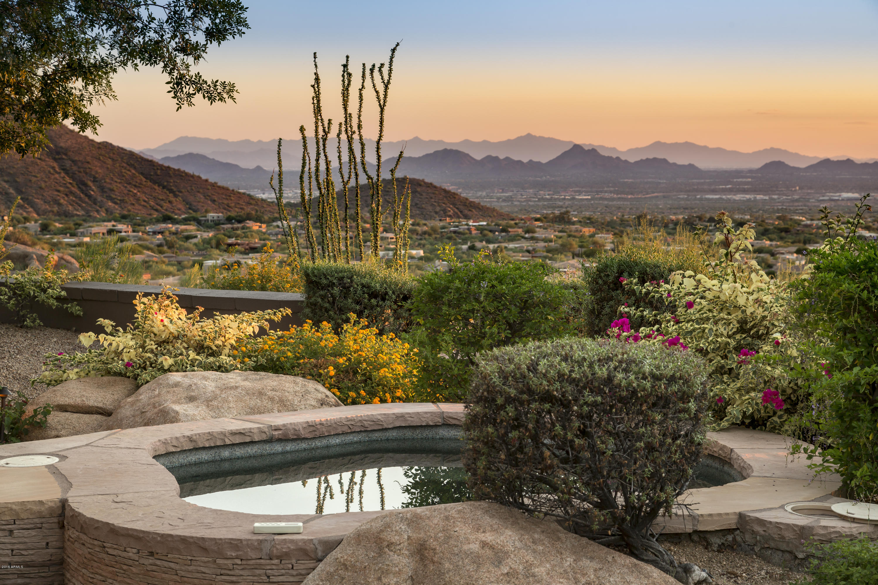 One of the most dramatic views in the entire valley!  Perched upon a hill in Troon's Artesano neighbhorhood, this Jessie Hill custom home stunner commands a 180 degree view of boulders, city lights and Pinnacle Peak.  Expansive full-length windows span the 45 ft great room, perfectly capturing this breathtaking view of the Valley below. Extreme customization and detailing found throughout, including gourmet kitchen with banco seating, extensive beam work,  wood and saltillo flooring, wall stone details, elevator, and custom wine room. Functional floor plan features a Master Bedroom plus three guest suites, office/media and Bar room. Lower level bedroom has separate kitchen and laundry Rm.  Dramatic exterior begins with flowing hillside fountain and continues with private master garden and patio, and culminates with a large covered patio, pool/spa, fire pit and BBQ center off the great room with unending city views.   For the buyer looking for turnkey, custom furnishings can be purchased on a separate bill of sale.  Adjacent vacant lot to convey to Buyer, included in the purchase price. Great location, views, guard-gated privacy, access to nearby golf and restaurants make this a perfect option for Scottsdale living.