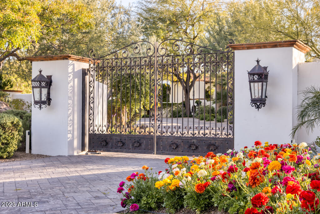 Secure and private with stunning views of Camelback Mountain; this modern Santa Barbara was recently updated with beautiful tile work, lighting, and cabinetry.  2.24 acres, 8,000+ square feet, 13 air-conditioned garages, a private well, a commercial-grade generator, privately gated, exquisite, mature landscaping; no details were missed when this home was originally built nor with the 2021-2022 updates.  Interior features include French limestone and wide plank walnut floors, honed marble countertops, custom hand-forged ironwork, and fabulous custom lighting throughout. 4 generously sized en-suite bedrooms in the main house plus a gracious  wood paneled office/library with French doors opening to the front courtyard fountain. 8 fireplaces glow on multiple courtyards most with fountains. The guest house at almost 1,000 square feet Is luxurious and comfortable with its own private veranda overlooking the putting green. A new, state-of-the-art Control 4 system completes the updates making this property safe, secure, easy to monitor, and so easy to enjoy.