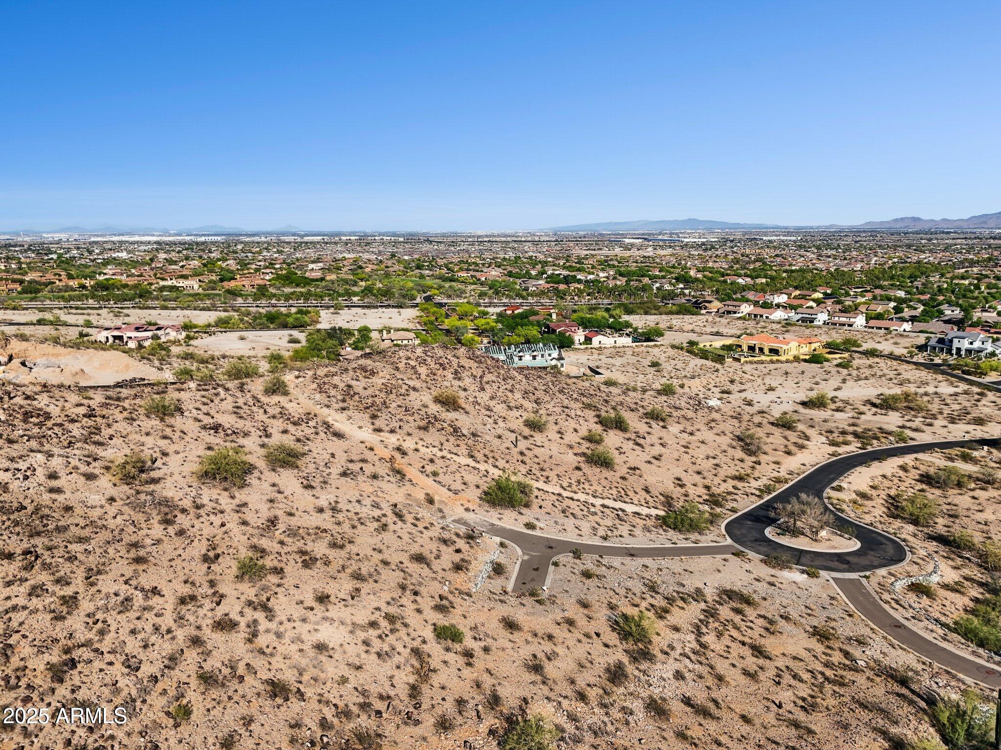 VIEWS, VIEWS, VIEWS! This stunning mountainside lot in the prestigious Verrado community delivers panoramic desert and mountain vistas you won't find anywhere else. Set against the White Tank Mountains, the homesite offers privacy, elevation, and the perfect backdrop for a custom luxury build. Living in Verrado means enjoying tree-lined streets, countless parks, miles of hiking and biking trails, two championship golf courses, and a vibrant Main Street with dining, shopping, and community events. A rare opportunity to create your dream home in one of Arizona's most sought-after neighborhoods.