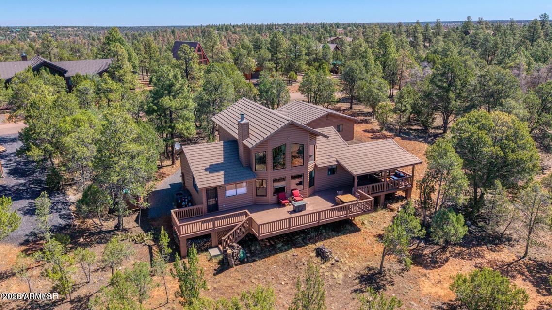 Nestled in the beautiful high country of Overgaard, Arizona, this charming cabin-style home offers privacy, panoramic views, and a peaceful setting among the tall pines. Located in the desirable Mogollon Airpark and situated toward the back of the subdivision, this property sits on just over an acre, providing added seclusion and room to enjoy the mountain lifestyle. The inviting floor plan features 3 bedrooms and 2 baths, including a loft bedroom with a privacy wall, a split-bedroom layout, a welcoming foyer, and an eat-in kitchen. Cozy up to the living room fireplace on cool mountain evenings or step outside from the kitchen onto the expansive back deck, where both open and covered spaces provide plenty of room for separate seating, dining, and entertaining areas. The deck... also offers private access from the primary bedroom, which includes a spacious en-suite bath. Additional highlights include an oversized garage with an EV charger and recently added flex room currently used as an office--ideal for a workout area, hobby room, guest overflow, or additional workspace. Recent upgrades include fresh interior paint, a new HVAC system, and new energy efficient living room windows adding comfort and value, while cement roof tiles offer added fire protection. With its cabin charm, thoughtful updates, generous deck space, and serene high-country setting, this Mogollon Airpark property is a wonderful opportunity to enjoy the best of mountain living in Overgaard. Ask to see it today! Be sure to open the QR code in the photos to see the seller improvements!