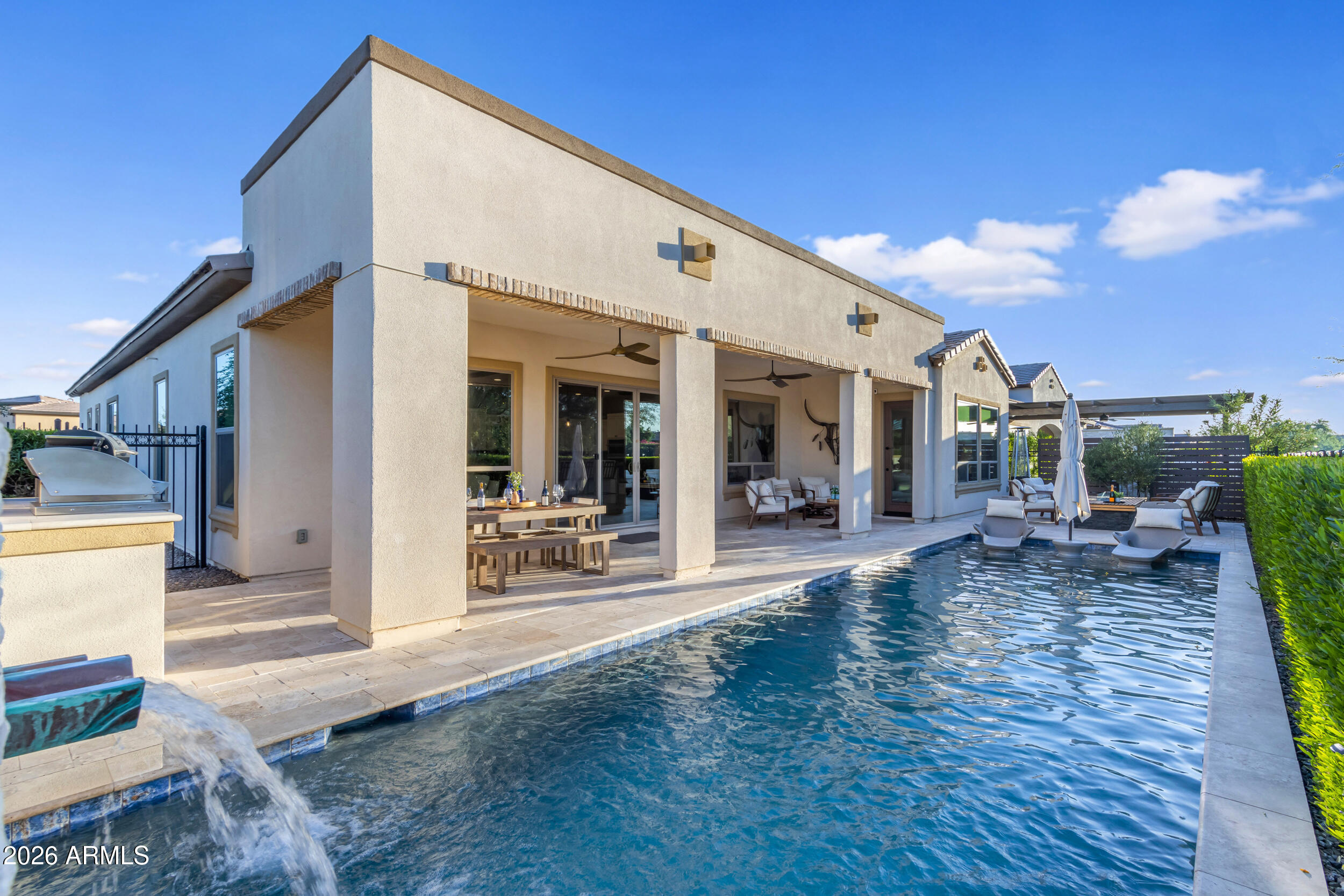 Sweeping golf course and tranquil lake views set the stage for this rare Cordoba floor plan (2BD, 2.5BA, Den, 4-car garage) w/ private pool. The premium elevated corner homesite with no immediate neighbors behind provides an added sense of privacy, openness, & peaceful outdoor living. With its contemporary finishes, this sanctuary impresses w/ outdoor-centric gourmet kitchen, GE Monogram appliances, built-in refrigerator, gas cooktop, quartz counters, all anchored by the oversized waterfall island. Upgraded luxury plank flooring flows seamlessly. Through sliding glass doors, step outside to your custom backyard oasis featuring heated pool w/ water feature wall, built-in kitchen w/ BBQ & firepit finished with travertine. Builder is SOLD OUT of lots to build the highly desirable Cordoba. Sellers are the original owners. Construction was completed and they moved in March 2023. The outdoor kitchen island is thoughtfully appointed with a Tec infrared BBQ, refrigerator, and custom storage drawers. The spacious primary suite offers a luxurious retreat featuring an oversized walk-in closet, dual vanities, soaking tub, walk-in shower with floor-to-ceiling tile, and private access to the patio and pool. Designed with a desirable split floor plan, the home also features an open den with custom built-in shelving along with a generously sized guest suite complete with an ensuite bath and walk-in shower. Additional enhancements include a fireplace with separate seating area, a glass-enclosed wine room, designer lighting throughout, two-tone paint, window sills, soft-close kitchen cabinetry with pull-out shelving, surround sound Infinity speakers, upgraded window treatments including electric shades in the primary suite, water softener, reverse osmosis system, tankless water heater, and an oversized four-car air-conditioned garage with epoxy flooring, custom lighting, and ceiling-mounted storage racks.   This home is perfectly located within the community just steps from the Algarve Clubhouse where you can enjoy swimming, dining, live music, dancing, the list is endless. The community is well-known for the award-winning, private Tom Lehman designed Golf Course. It has every amenity imaginable: pickleball, tennis, bocce, state of the art health & fitness center, Alvea Spa, just to name a few. The list of community activities is never-ending: concerts, classes, social clubs, car shows, events and much more. Eateries include: La Palma (the signature restaurant, in a beautiful atmosphere with panoramic views), Bodega Wine and Café (for small plates and wine tasting), and the Solaz and Algarve pool Grills. There are four pools to enjoy. The Solaz pool sits adjacent to the golf course with stunning views. The Algarve, the adult-only pool, is perfect for a little added relaxation. Join the Fun and the Good Life at Encanterra!