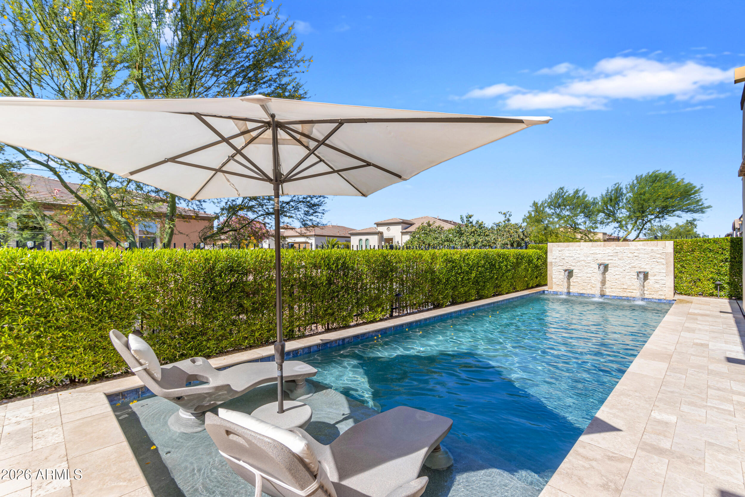 Sweeping golf course and tranquil lake views set the stage for this rare Cordoba floor plan (2BD, 2.5BA, Den, 4-car garage) w/ private pool. The premium elevated corner homesite with no immediate neighbors behind provides an added sense of privacy, openness, & peaceful outdoor living. With its contemporary finishes, this sanctuary impresses w/ outdoor-centric gourmet kitchen, GE Monogram appliances, built-in refrigerator, gas cooktop, quartz counters, all anchored by the oversized waterfall island. Upgraded luxury plank flooring flows seamlessly. Through sliding glass doors, step outside to your custom backyard oasis featuring heated pool w/ water feature wall, built-in kitchen w/ BBQ & firepit finished with travertine. Builder is SOLD OUT of lots to build the highly desirable Cordoba. Sellers are the original owners. Construction was completed and they moved in March 2023. The outdoor kitchen island is thoughtfully appointed with a Tec infrared BBQ, refrigerator, and custom storage drawers. The spacious primary suite offers a luxurious retreat featuring an oversized walk-in closet, dual vanities, soaking tub, walk-in shower with floor-to-ceiling tile, and private access to the patio and pool. Designed with a desirable split floor plan, the home also features an open den with custom built-in shelving along with a generously sized guest suite complete with an ensuite bath and walk-in shower. Additional enhancements include a fireplace with separate seating area, a glass-enclosed wine room, designer lighting throughout, two-tone paint, window sills, soft-close kitchen cabinetry with pull-out shelving, surround sound Infinity speakers, upgraded window treatments including electric shades in the primary suite, water softener, reverse osmosis system, tankless water heater, and an oversized four-car air-conditioned garage with epoxy flooring, custom lighting, and ceiling-mounted storage racks.   This home is perfectly located within the community just steps from the Algarve Clubhouse where you can enjoy swimming, dining, live music, dancing, the list is endless. The community is well-known for the award-winning, private Tom Lehman designed Golf Course. It has every amenity imaginable: pickleball, tennis, bocce, state of the art health & fitness center, Alvea Spa, just to name a few. The list of community activities is never-ending: concerts, classes, social clubs, car shows, events and much more. Eateries include: La Palma (the signature restaurant, in a beautiful atmosphere with panoramic views), Bodega Wine and Café (for small plates and wine tasting), and the Solaz and Algarve pool Grills. There are four pools to enjoy. The Solaz pool sits adjacent to the golf course with stunning views. The Algarve, the adult-only pool, is perfect for a little added relaxation. Join the Fun and the Good Life at Encanterra!