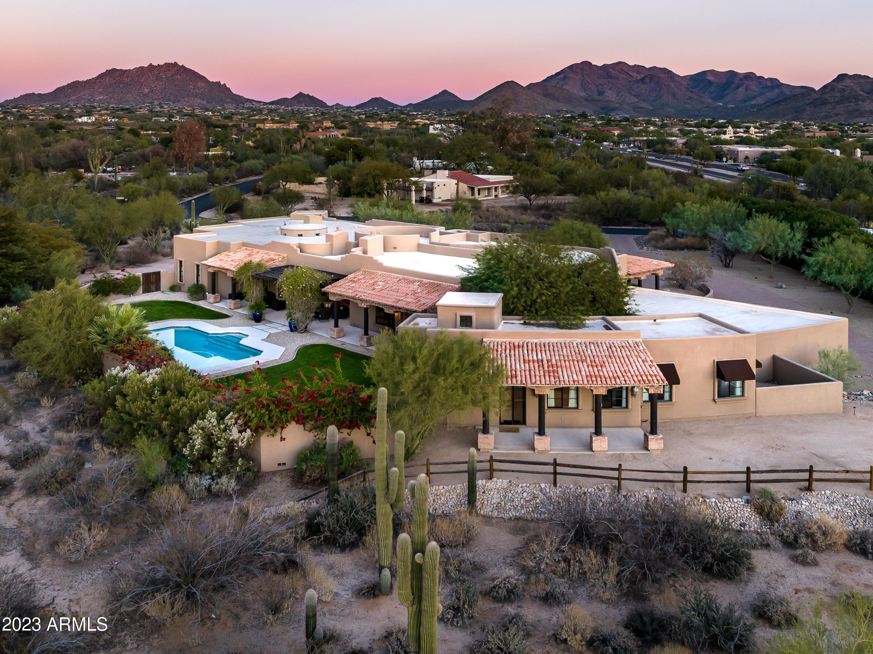 Prime Pinnacle Peak Location - this sprawling custom estate is located behind the gates of Pinnacle Paradise and provides the best in privacy and location.  The sprawling grounds cover close to 2 acres including the main house, separate guesthouse, four car garage, large resort style pool and grass area and expansive auto court with circle drive.  The main house captures picturesque views of the McDowell Mountains and pristine desert surroundings, with an open floorplan perfect for entertaining and guests.  A large Primary retreat, private guestrooms, large office, lower-level game room/bonus room and fully-appointed one bedroom guesthouse complete this one-of-a-kind property. NEW ROOF IN AUGUST 2024. Enjoy stunning sunset and mountain views from the large rooftop view deck or relax by the pool in the secluded backyard sanctuary. This estate offers the best of Arizona living and is just minutes from DC Ranch, The Quarter, Kierland and several top resorts that North Scottsdale has to offer.